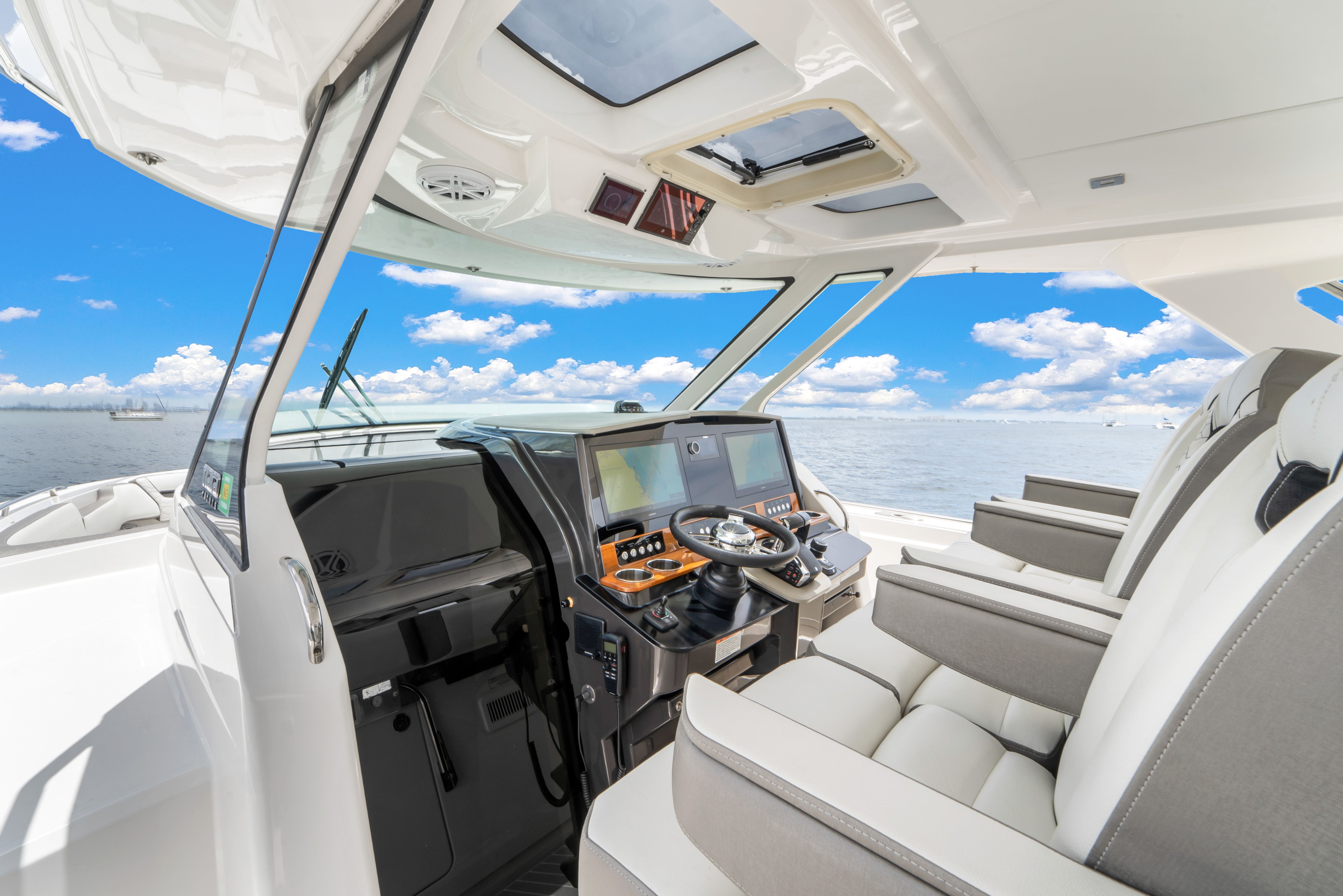 The cockpit of a 2023 Tiara Yachts 38 LS with modern instruments and comfortable seating.