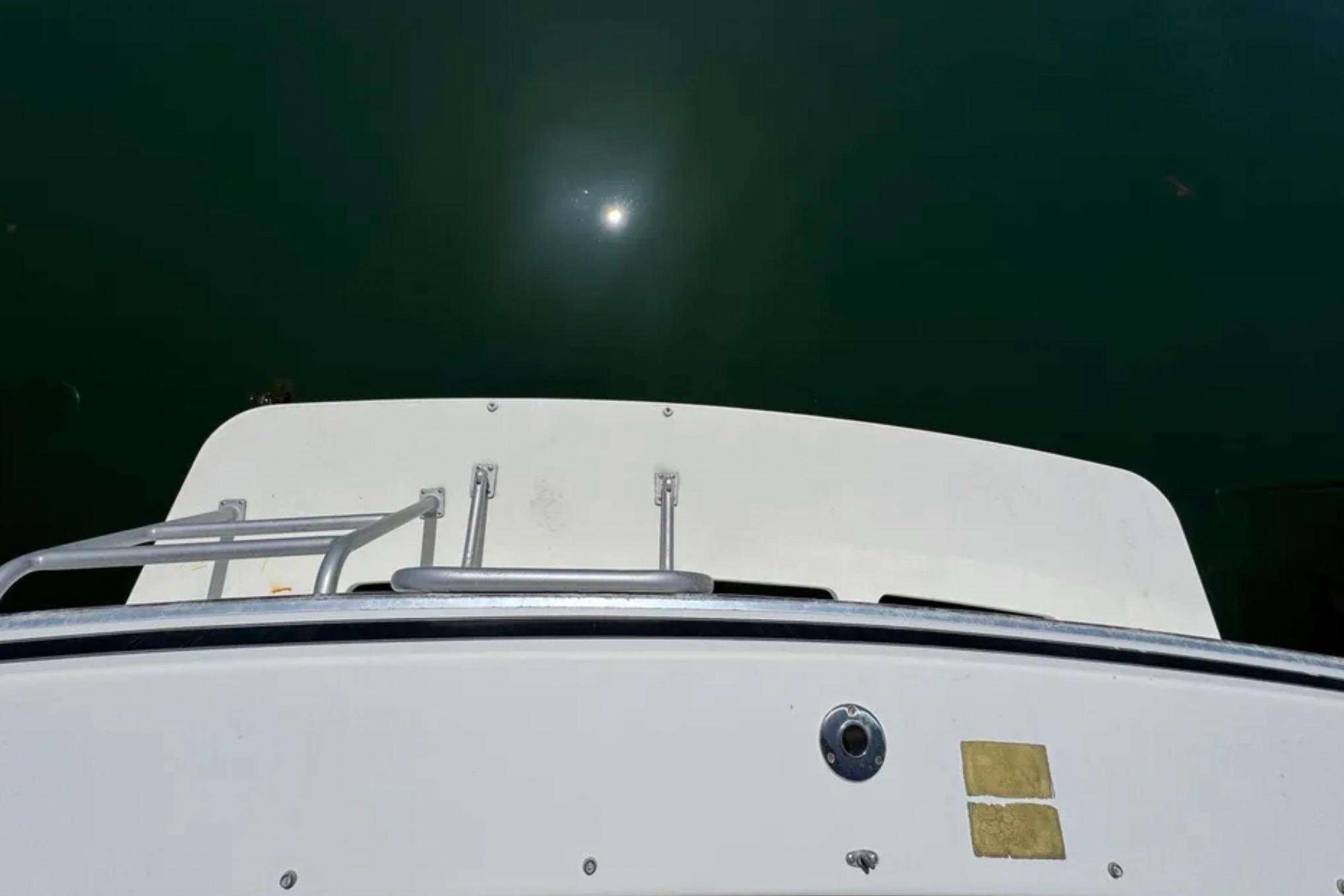 1988 Bertram 28 Sport Fisherman boat deck with sun reflection on water.