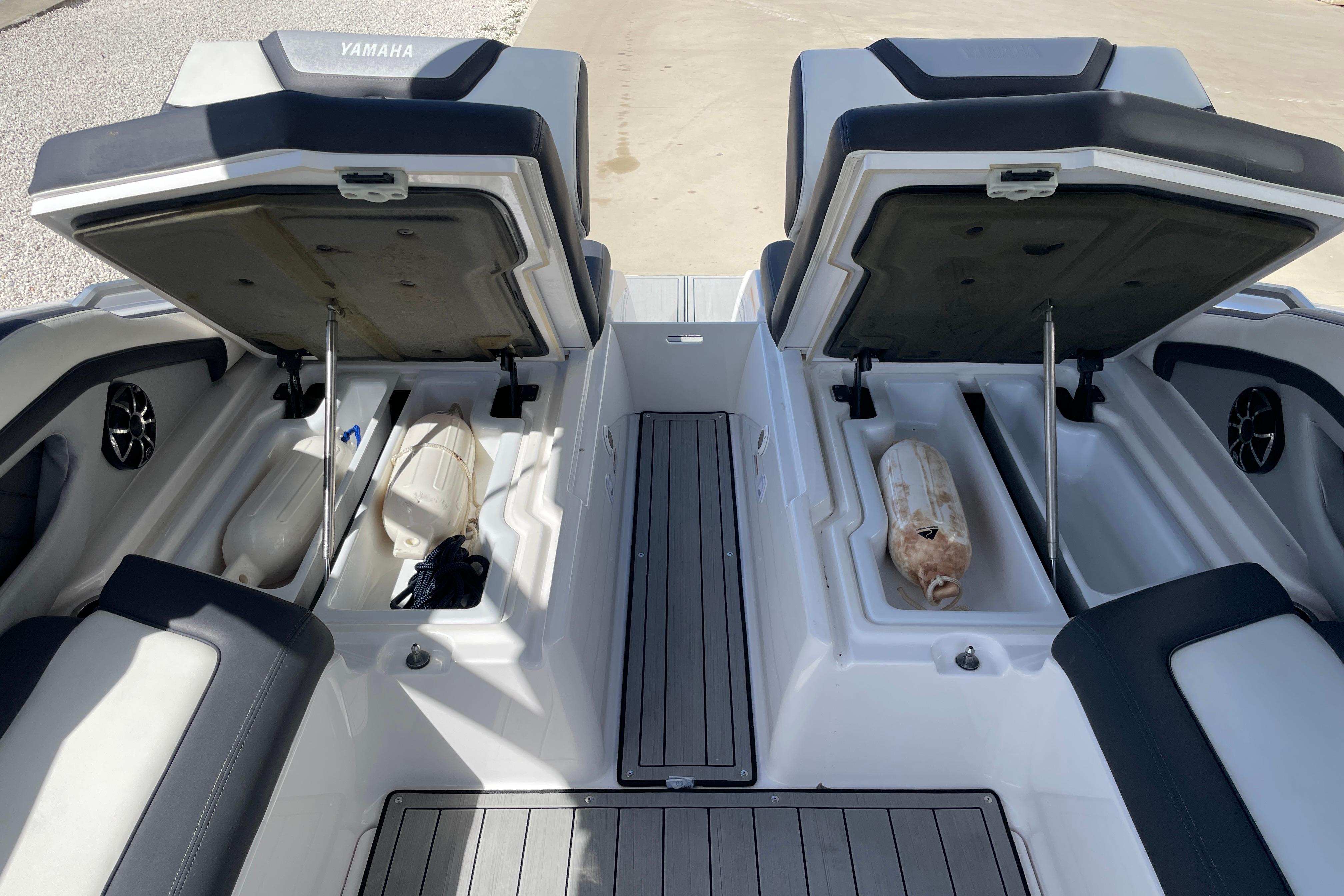 2021 Yamaha Boats 275SE storage compartments open, showcasing interior space and seating.