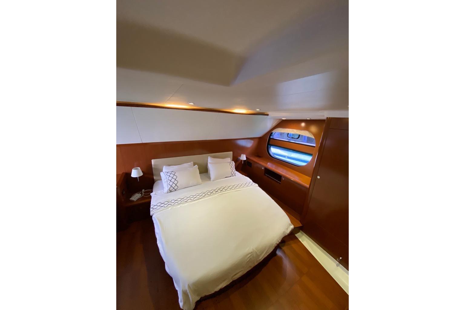 Luxurious bedroom interior of 2012 Beneteau Swift Trawler 52 with elegant wood finish.