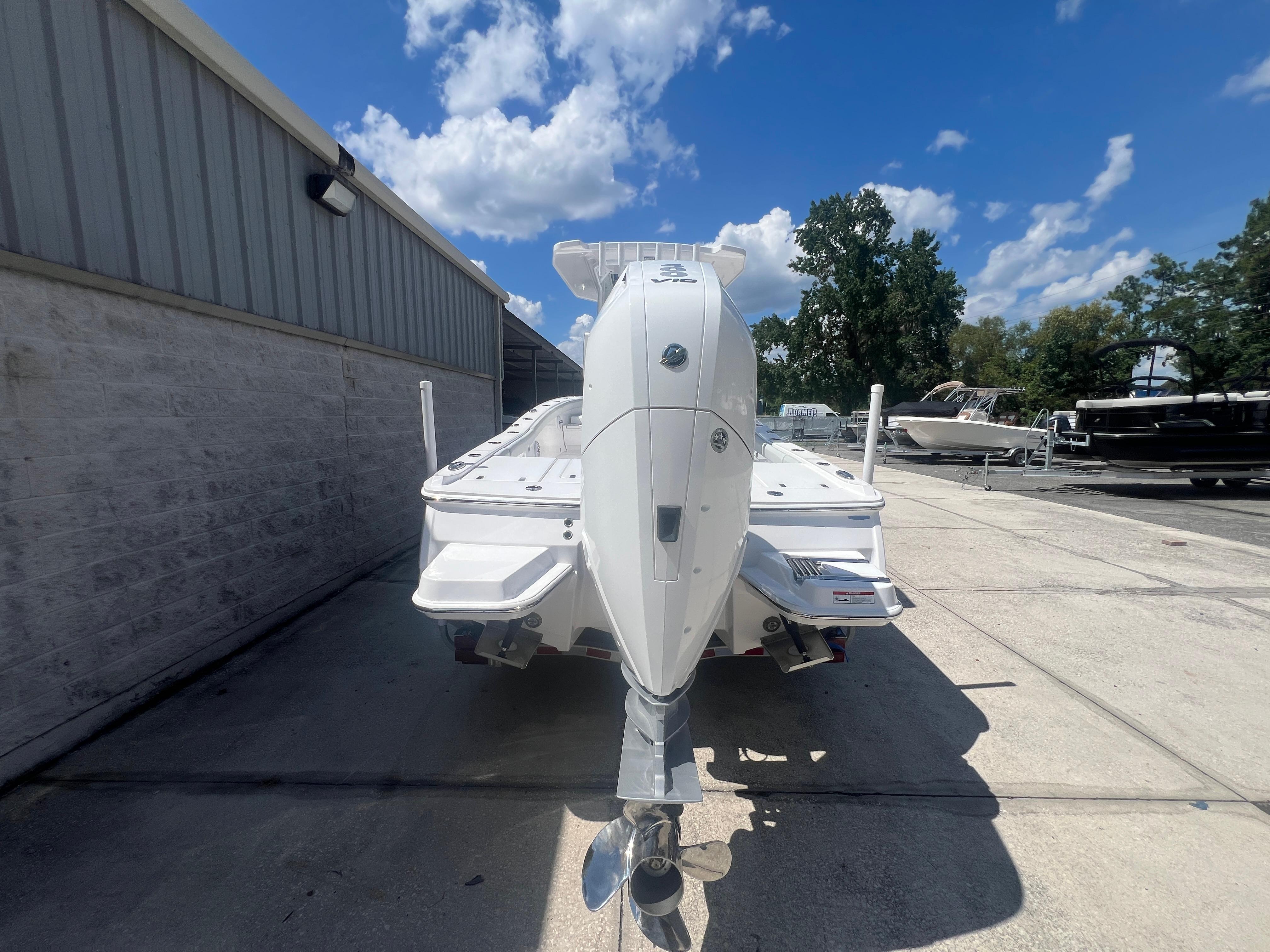 2026 Blackfin 262 HB boat with powerful outboard motor, parked outdoors under a clear blue sky.
