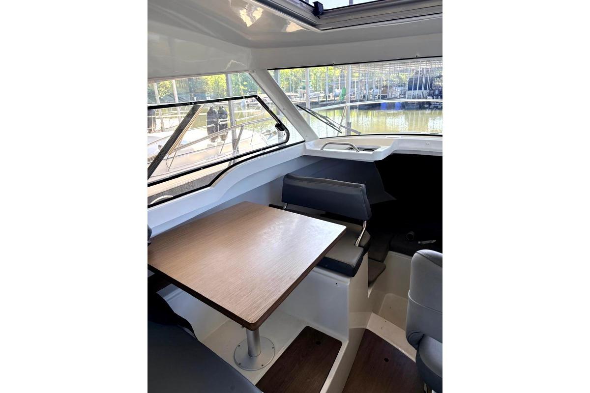 Interior of 2023 Beneteau Antares 7 boat with seating and table.