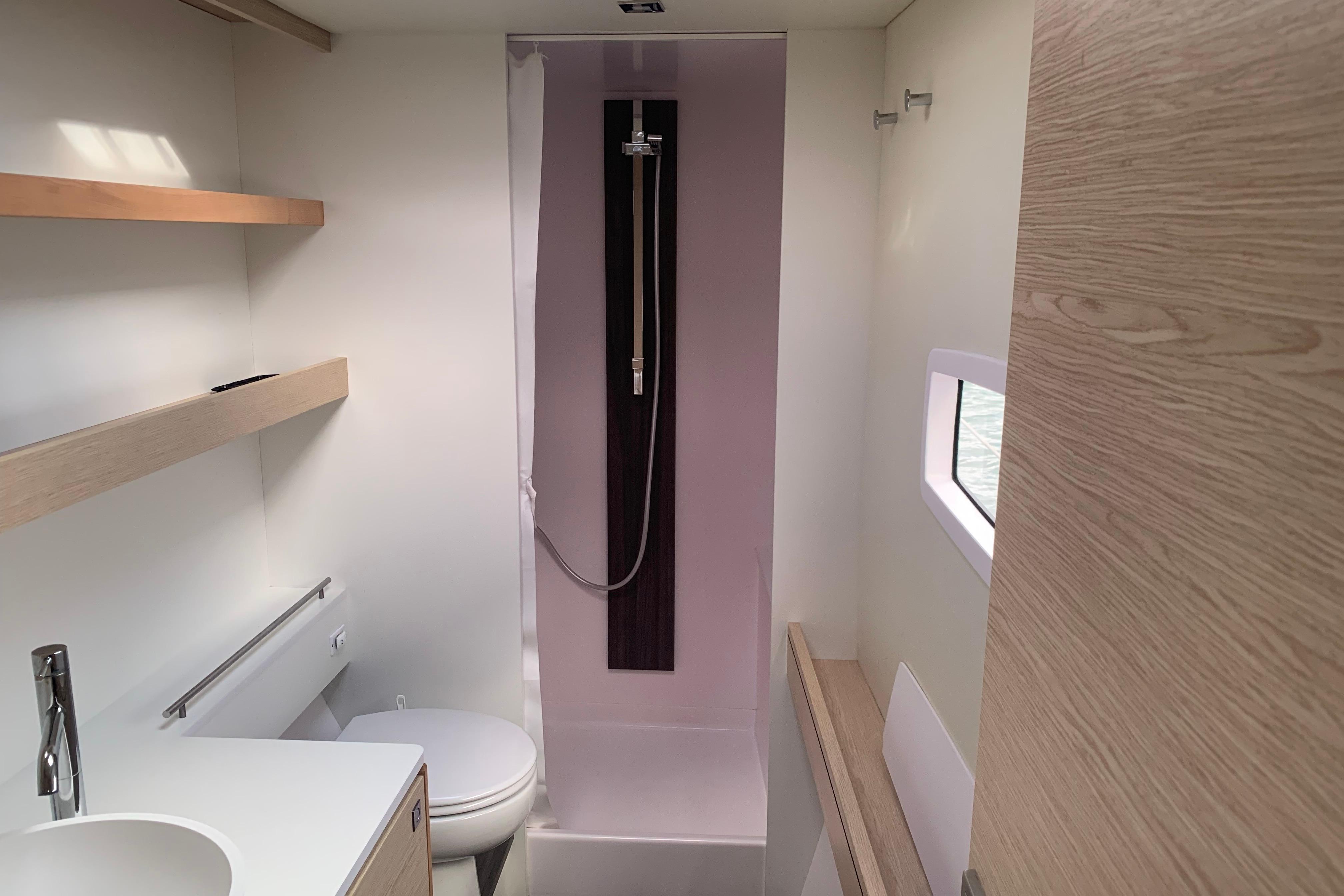 Modern bathroom interior of 2024 Outremer 45 yacht, featuring shower, toilet, and sleek design.