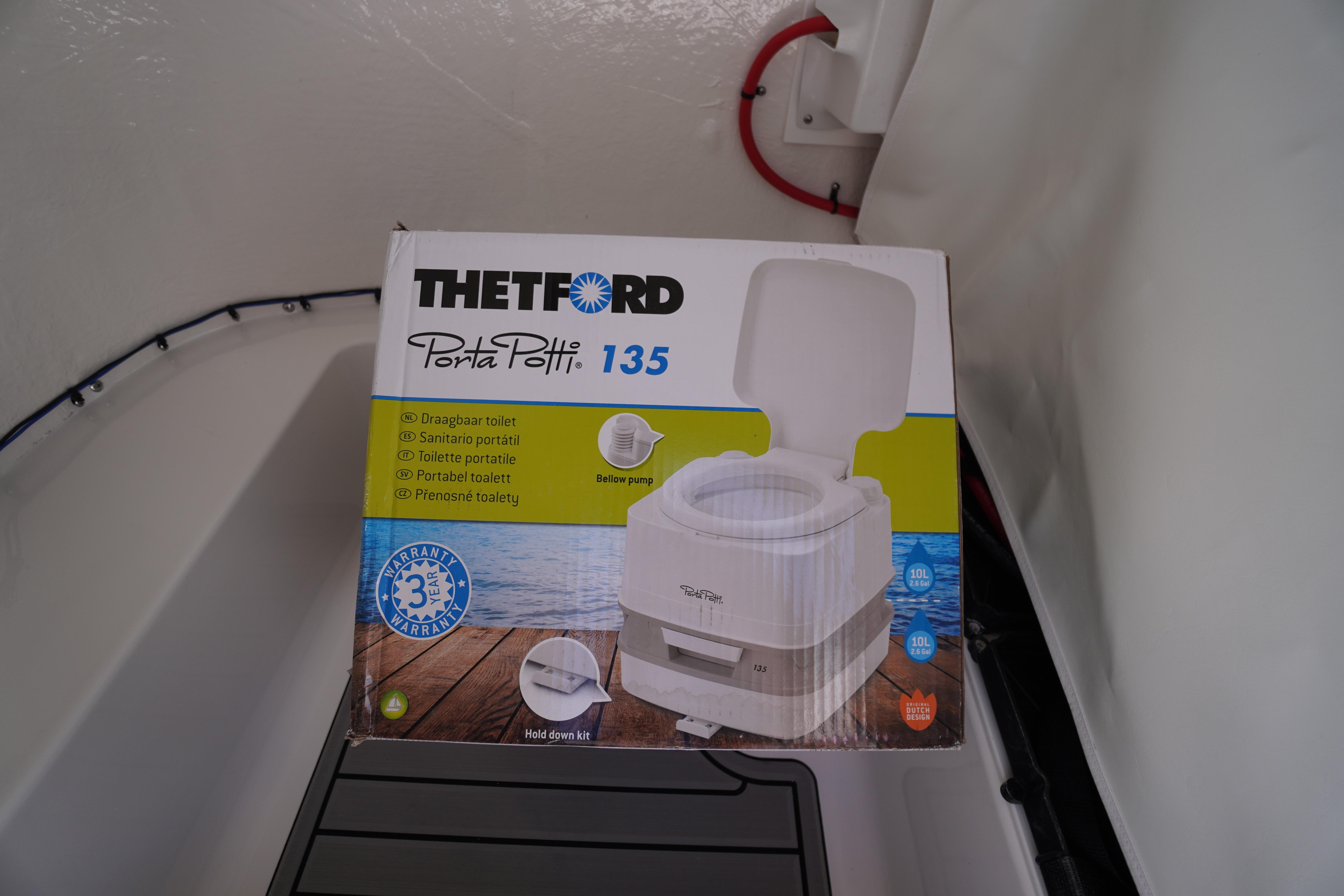 Portable toilet box inside 2026 Tidewater 220 CC Adventure boat cabin.