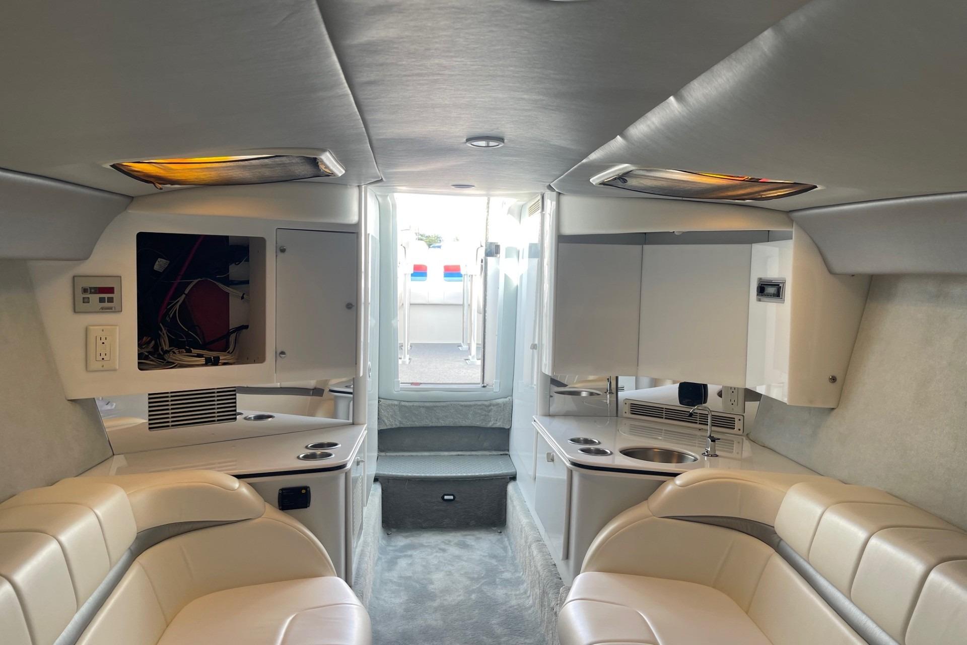 2004 Formula 382 FASTech boat interior with white seating and compact kitchenette.