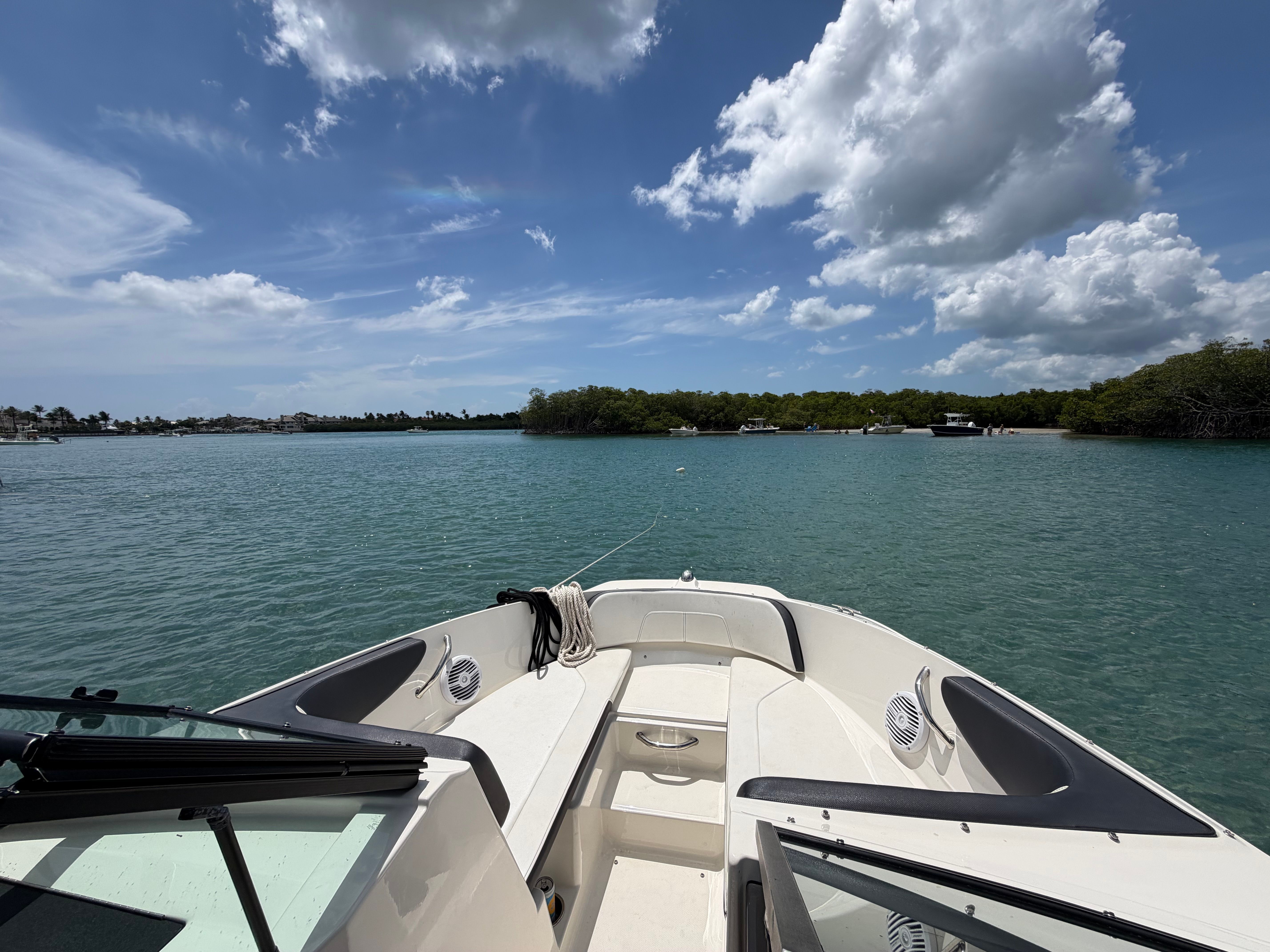A 2018 Sea Ray SPX 210 boat on calm water with a cloudy sky.