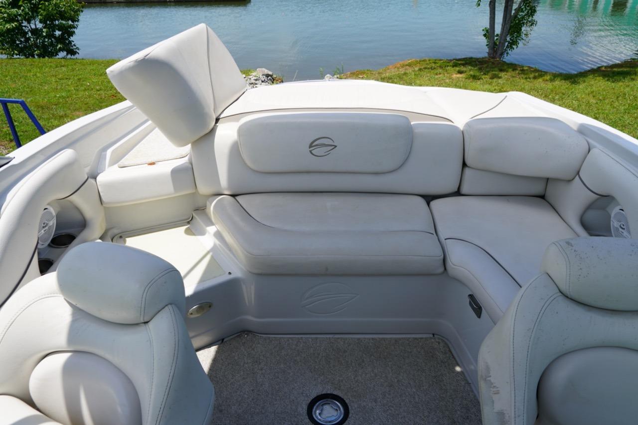 2004 Crownline 216 LS boat interior with white leather seating by a lake.