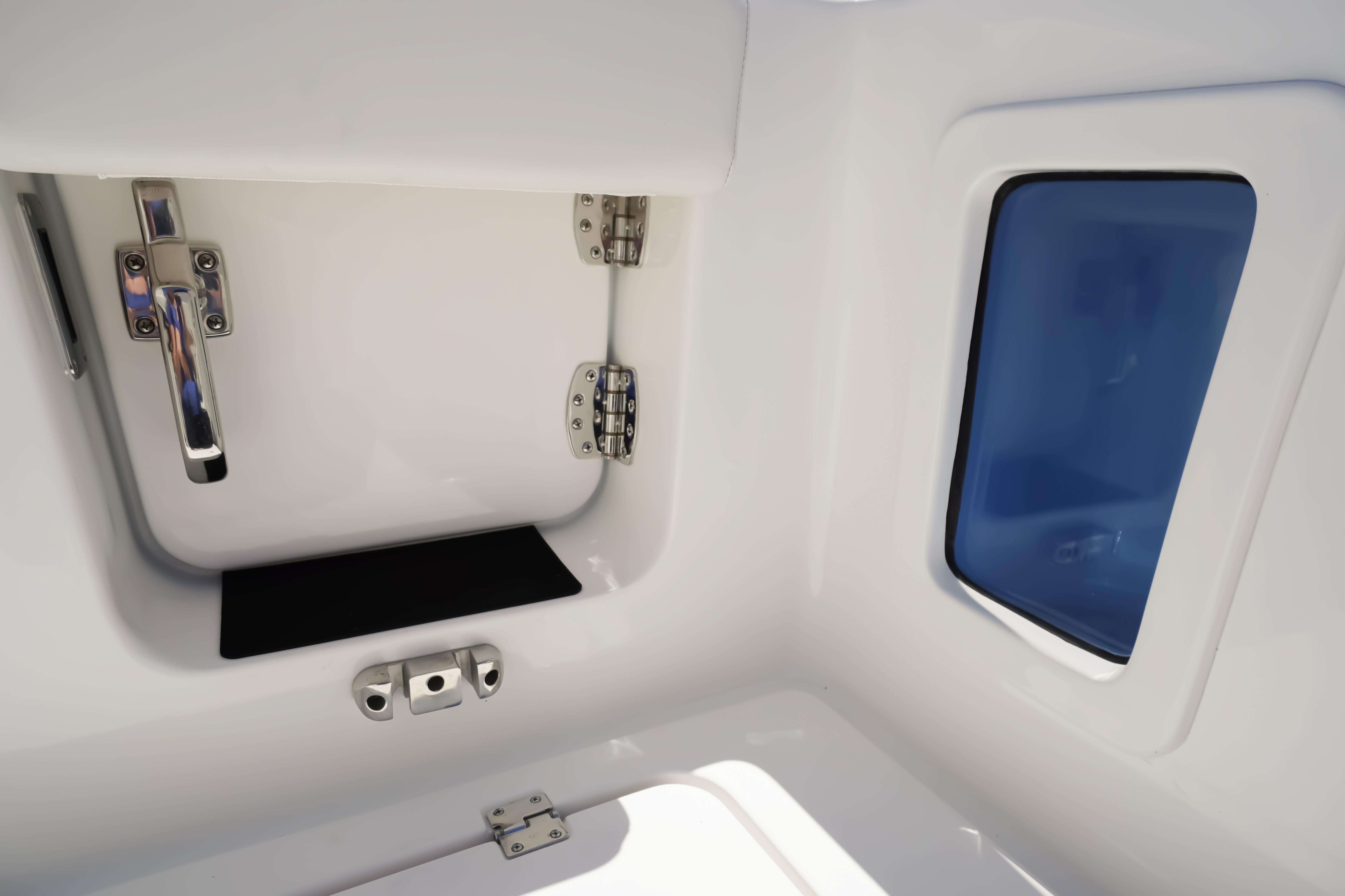 Interior view of 2026 Tidewater 302 CC Adventure boat, featuring storage compartment and window.