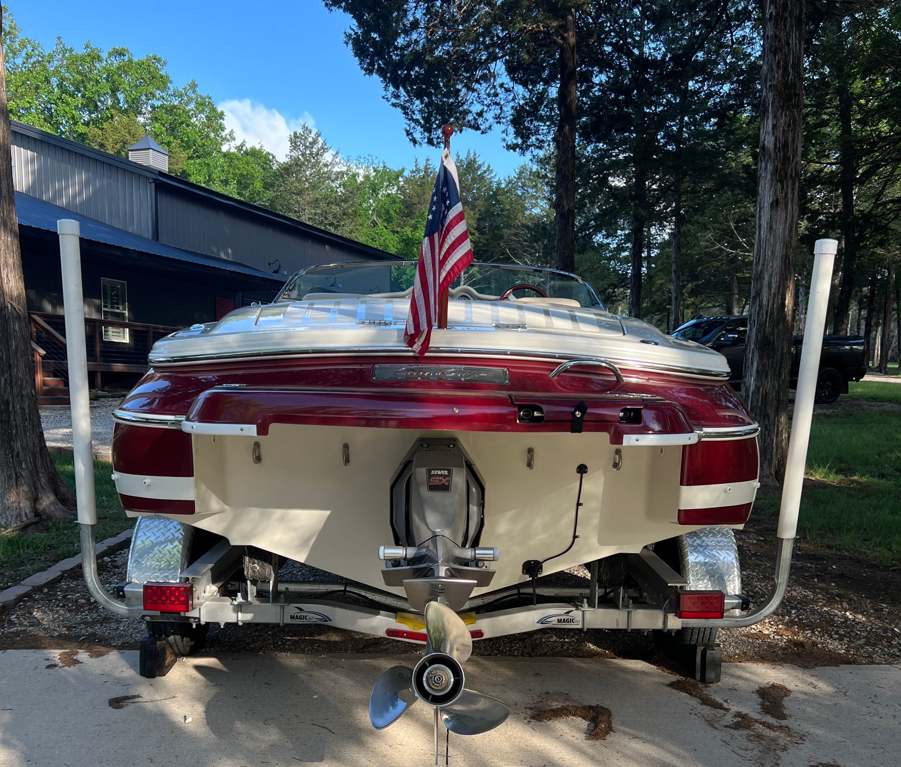 A 2006 Chris-Craft Speedster 20 on a trailer, surrounded by trees.
