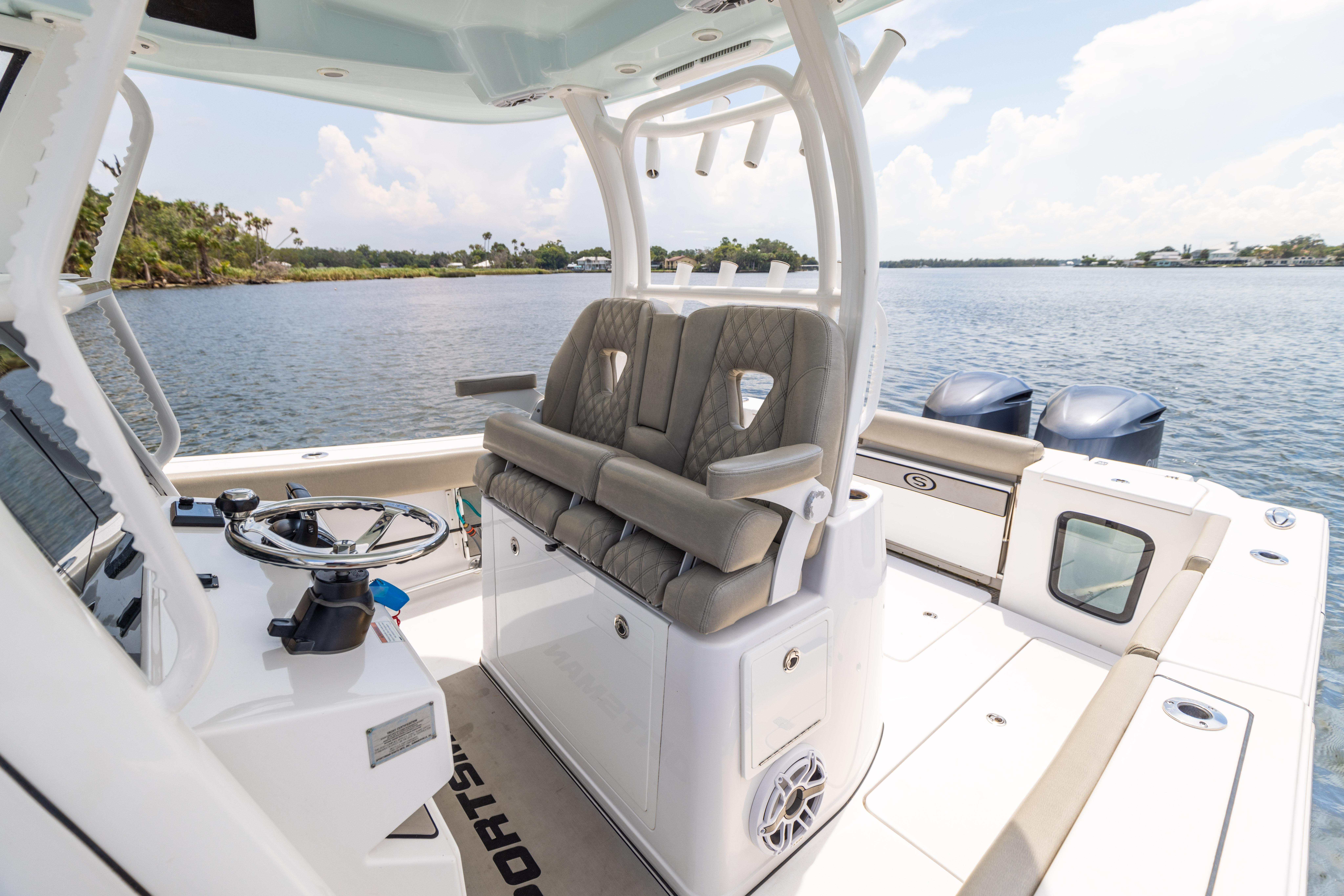 2021 Sportsman Open 302 Center Console boat interior with dual engines on a calm lake.