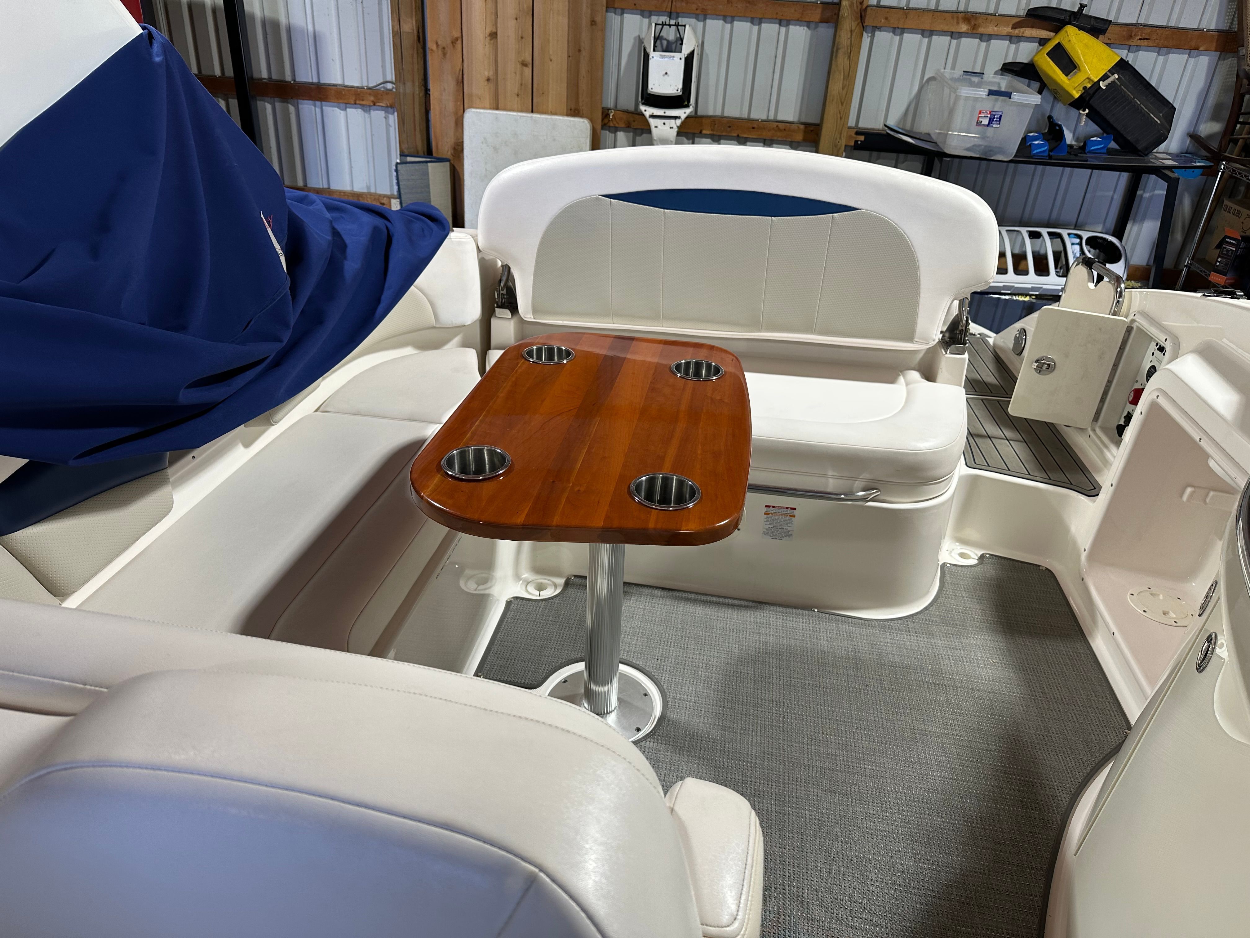 Interior of a 2011 Chaparral 287 SSX with white upholstery and a wooden table.