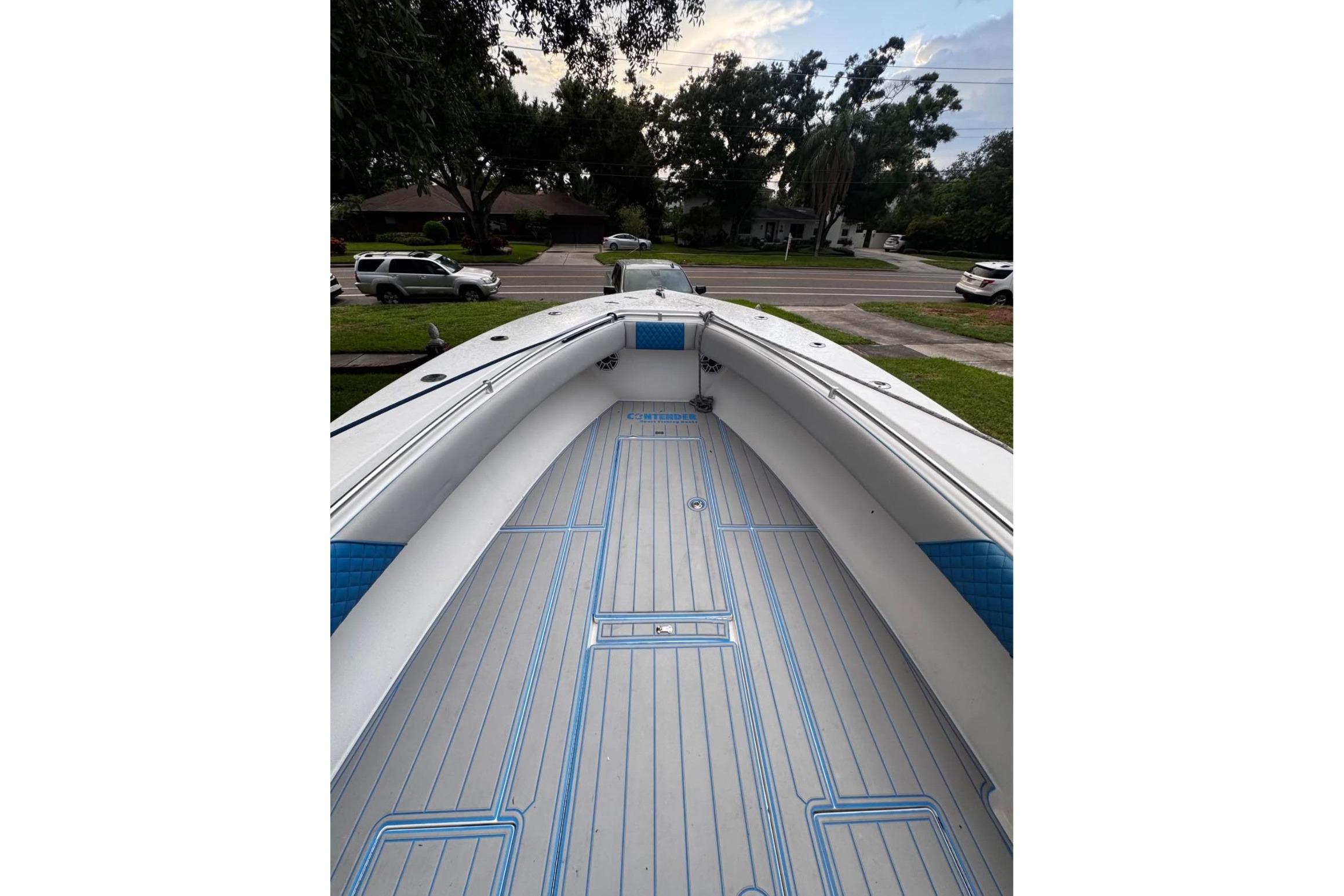 2005 Contender 31 Open boat interior with blue accents, parked in a residential area.