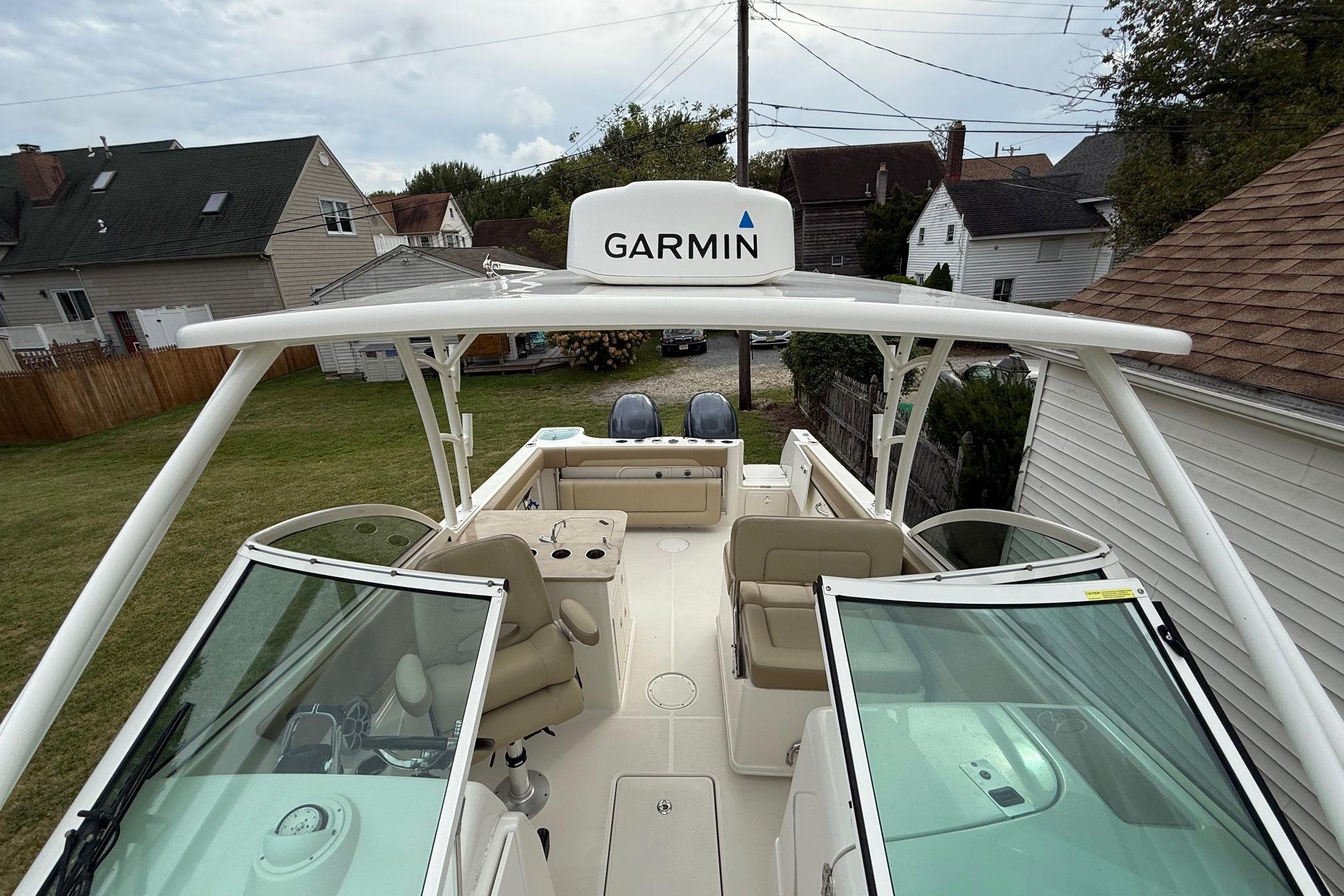 2019 Sailfish 275 DC boat with Garmin equipment, docked near residential area.