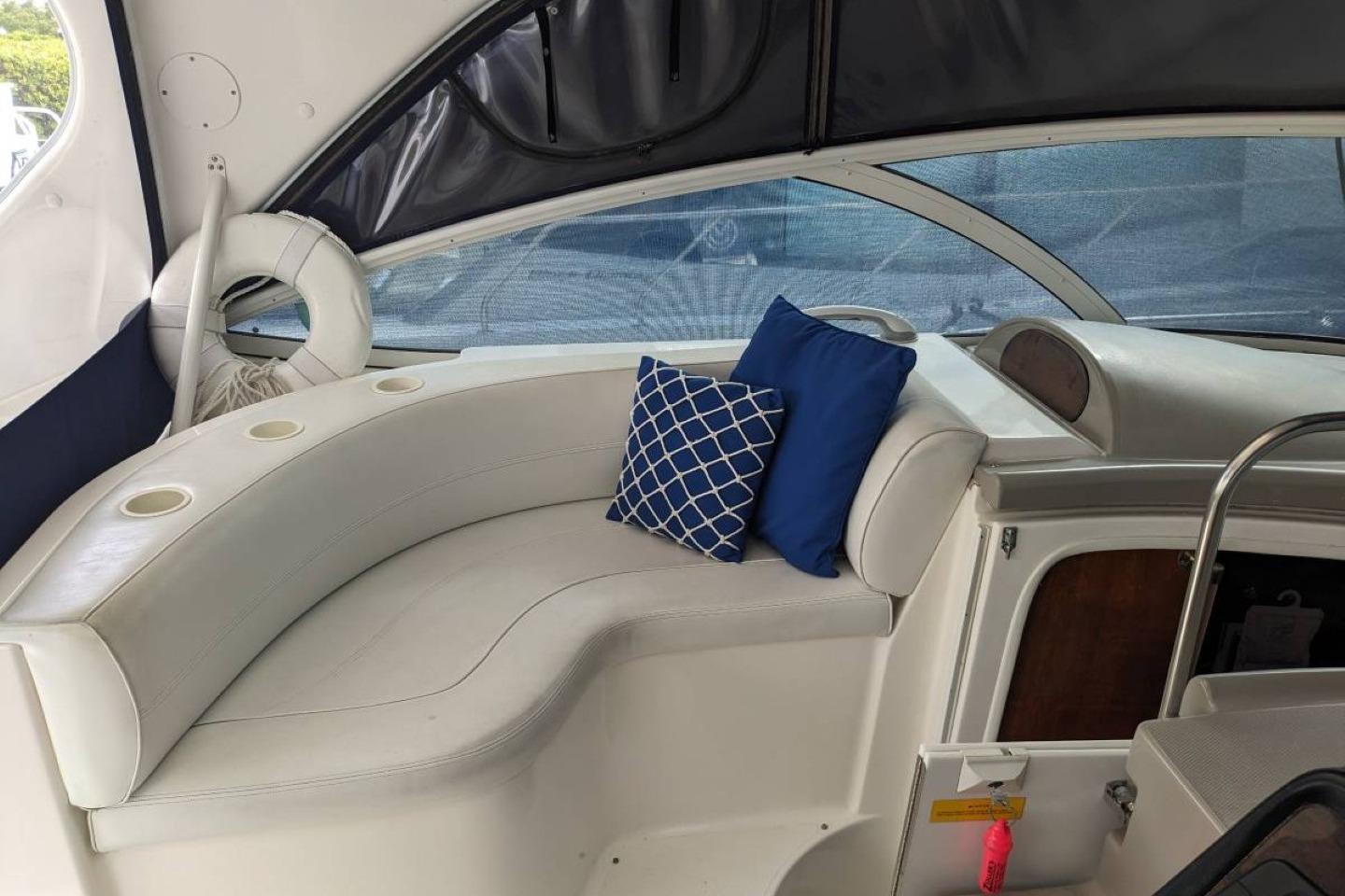 Interior of 2003 Cruisers 3970 yacht with white seating and blue cushions.