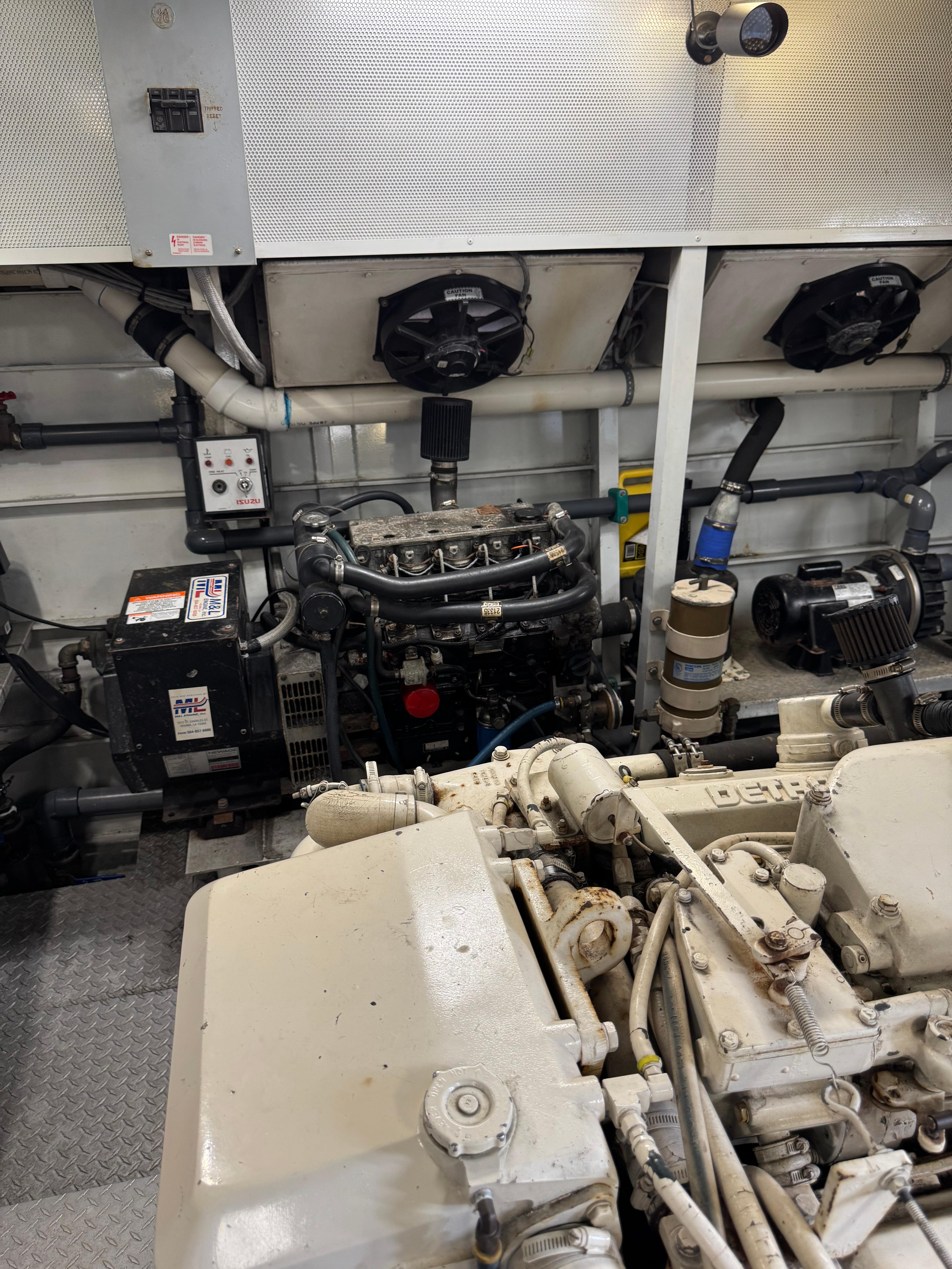 Engine room of a 2003 custom houseboat with visible machinery and components.