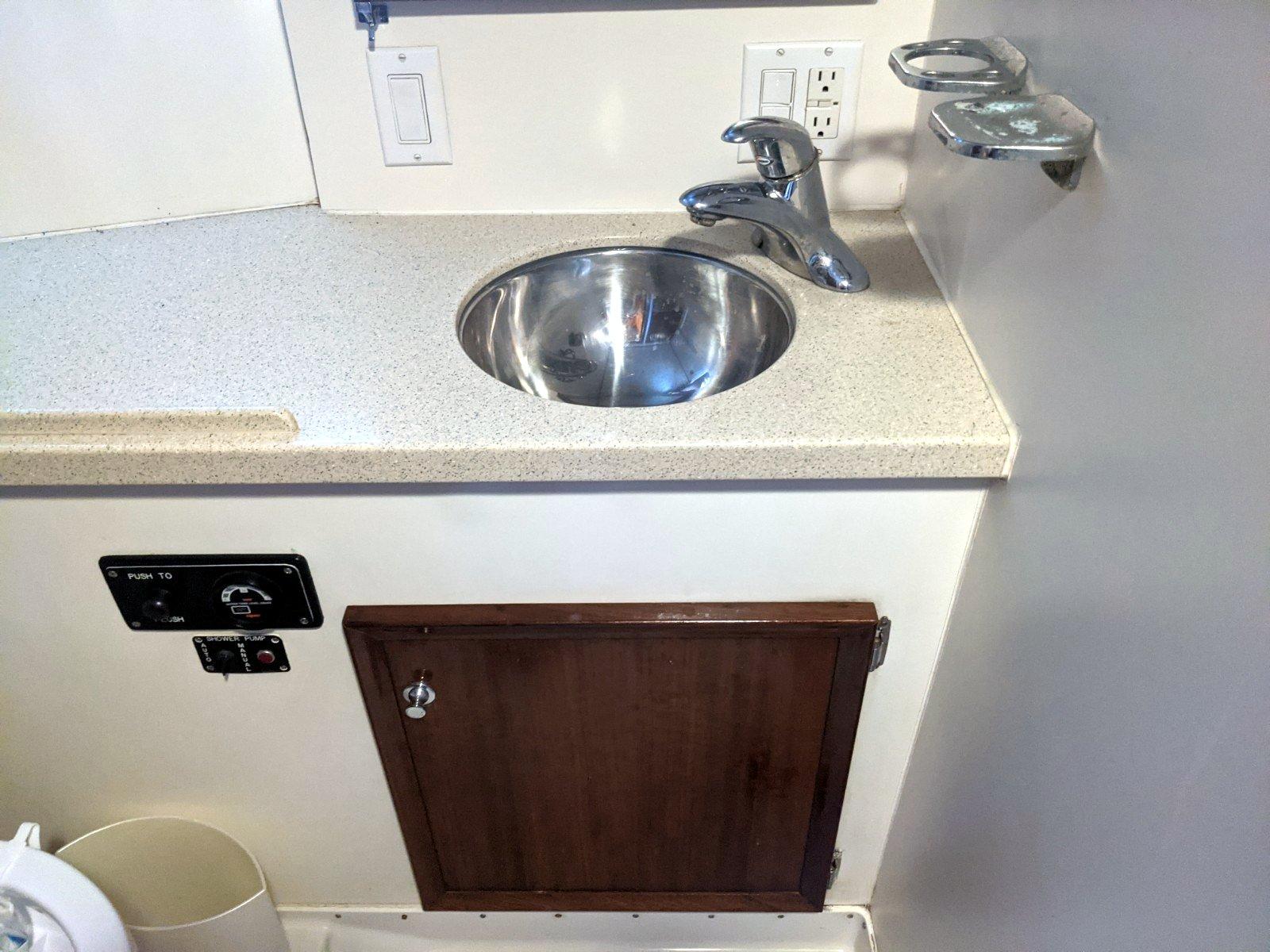 1977 Hatteras 46 Convertible yacht bathroom sink with countertop and storage cabinet.
