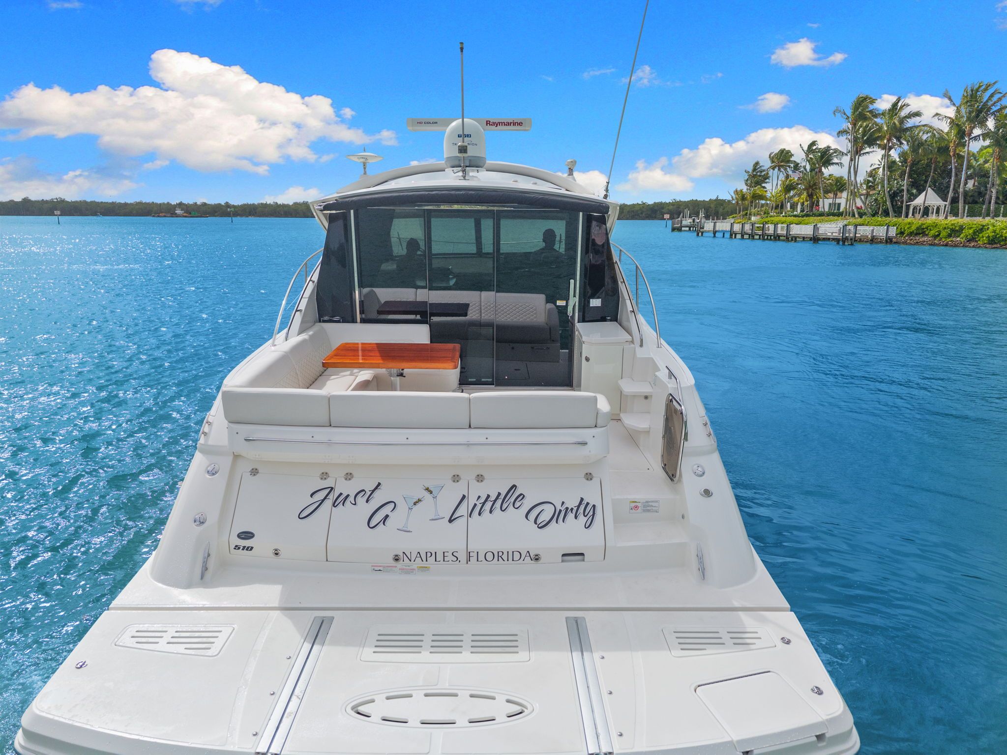 A 2017 Sea Ray Sundancer 510 on blue water, featuring an open seating area at the back.