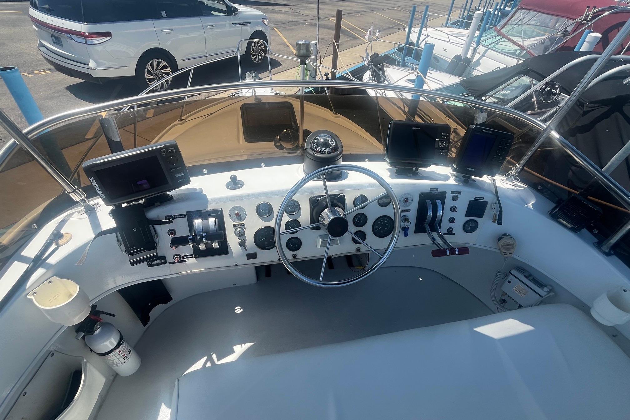 1988 Seafox 29 Flybridge helm with steering wheel, gauges, and navigation equipment.