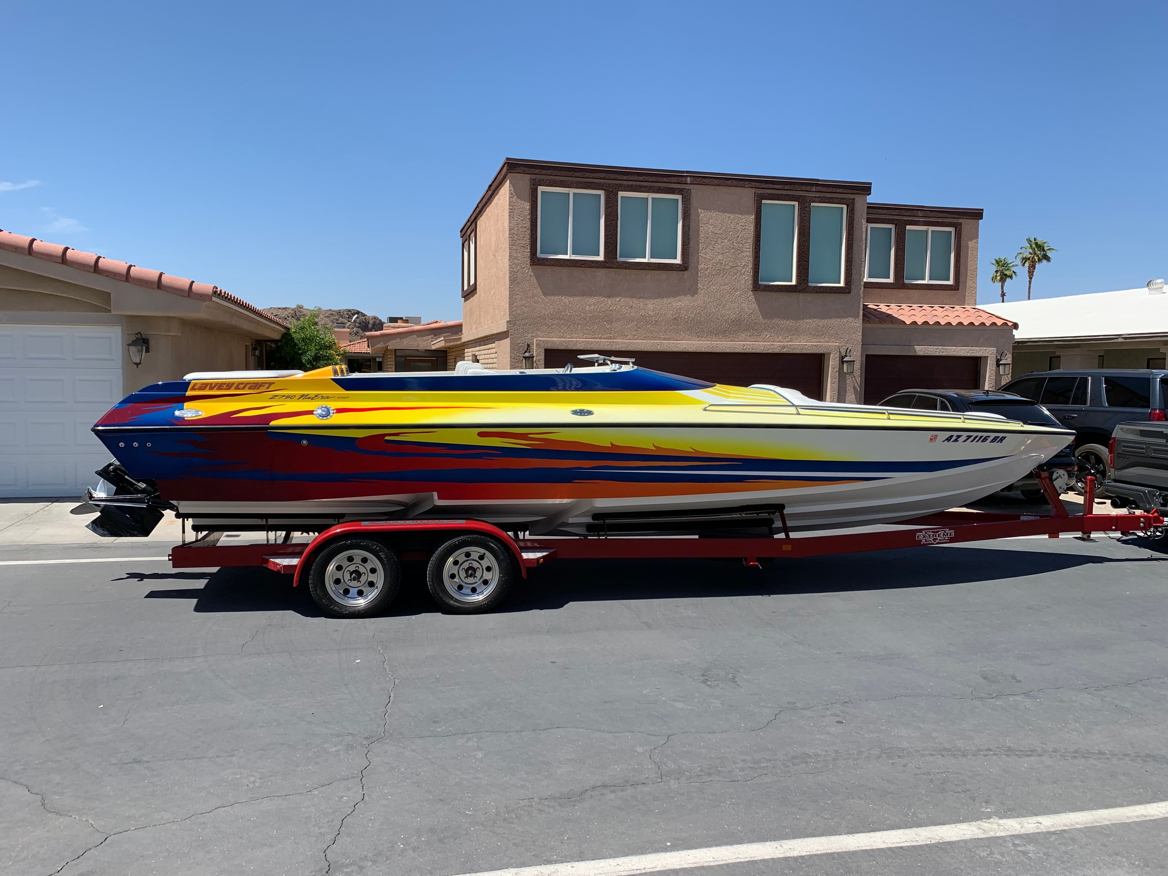 2002 Lavey Craft 2750 NUERA boat on trailer in front of house.