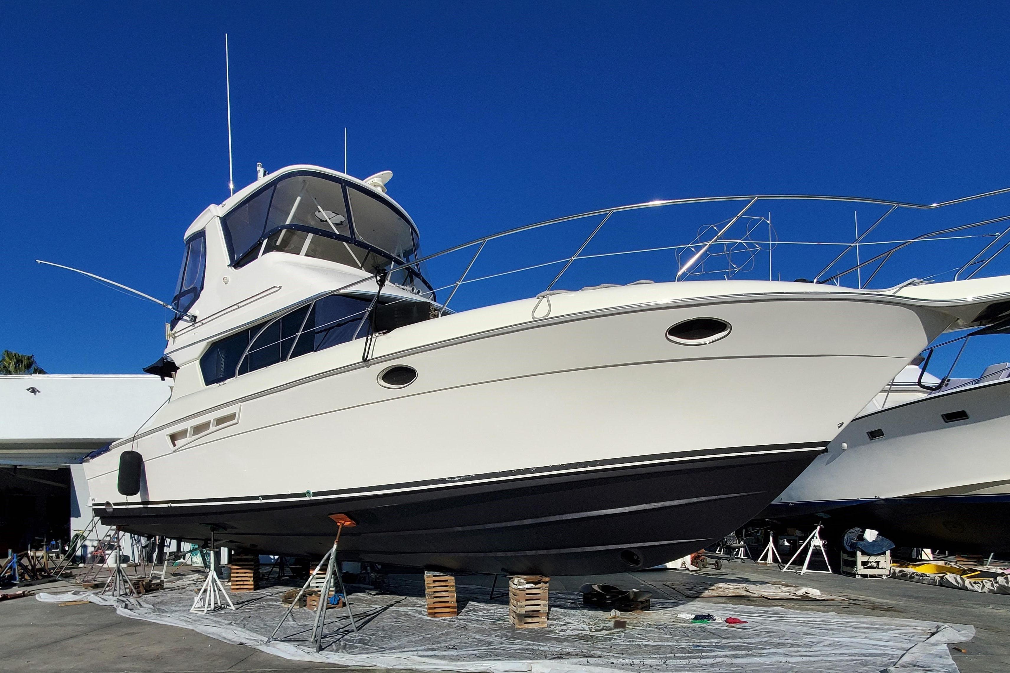2000 Silverton 42 Convertible yacht on dry dock under clear blue sky.