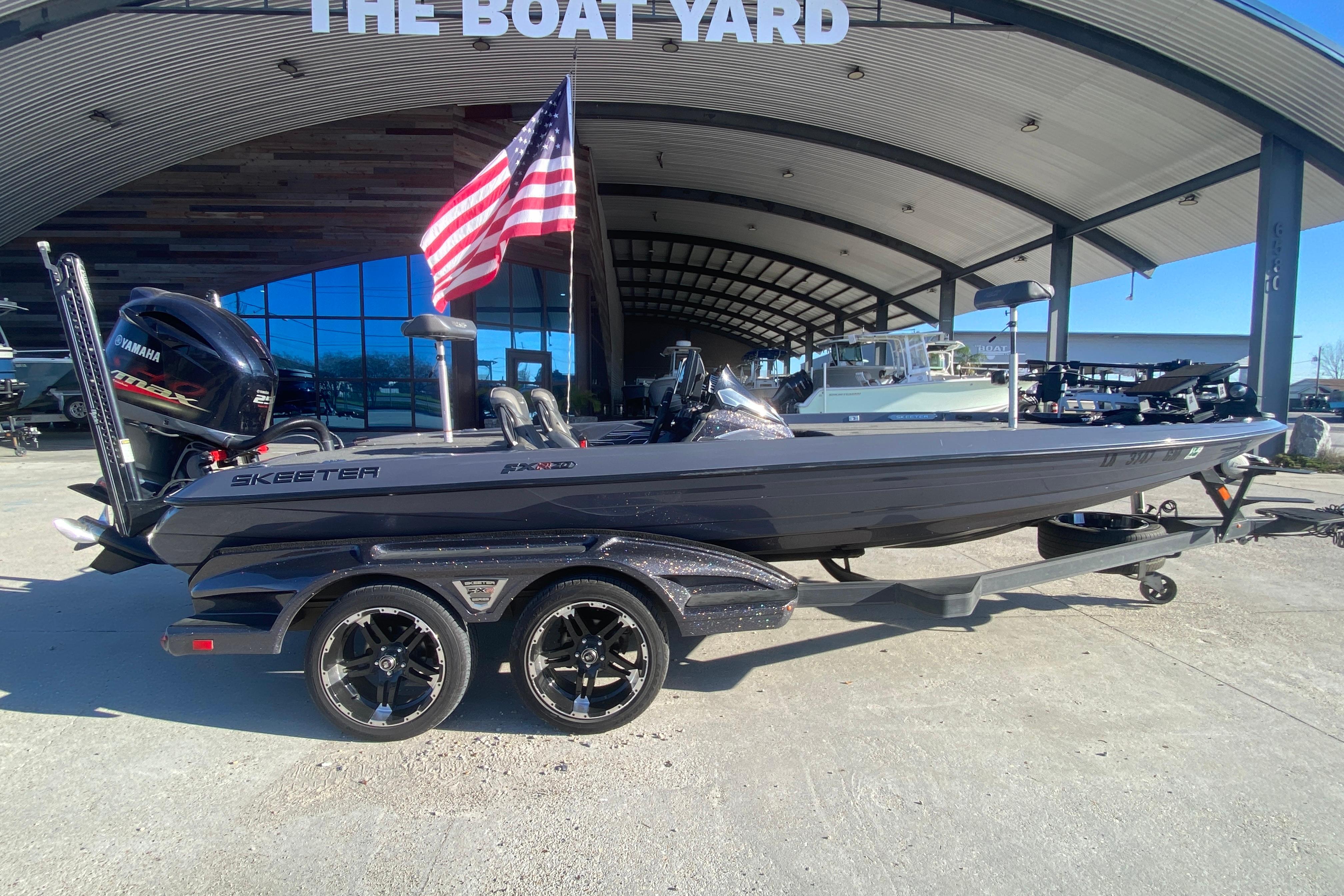 2020 Skeeter FXR20 Limited boat with Yamaha engine at dealership, American flag displayed.