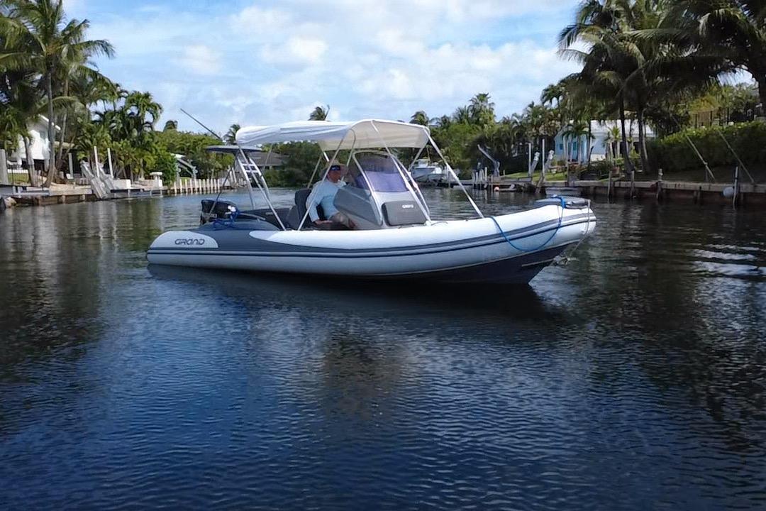 2020 Grand Inflatables G580 boat cruising on a calm, tropical waterway.