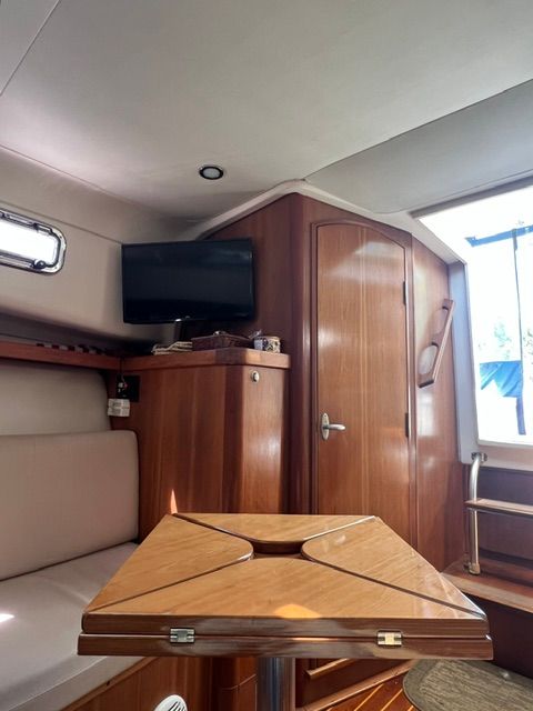 Interior of a 2003 Mainship Pilot 30-II yacht with wooden furnishings.