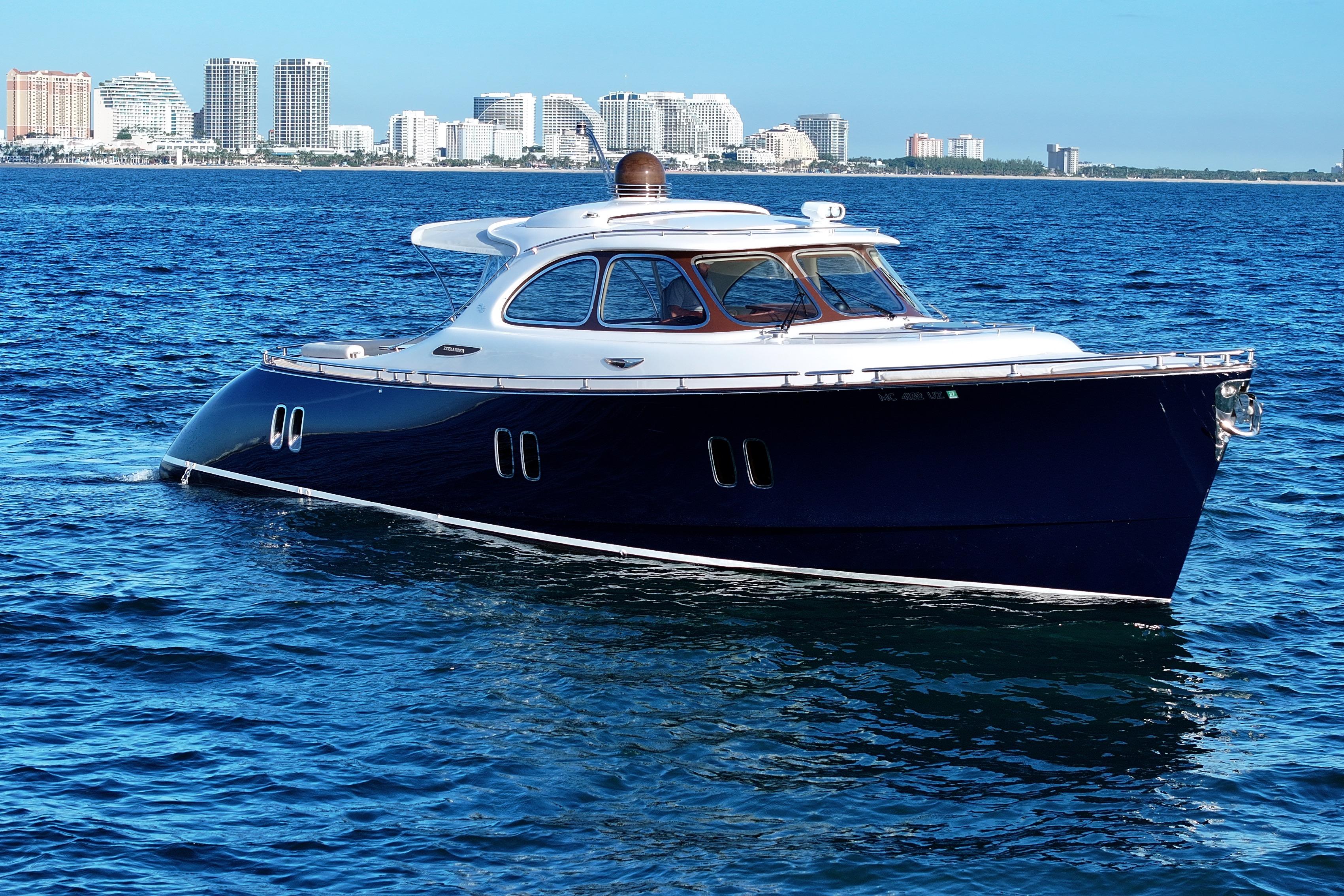 2013 Zeelander Z44 yacht cruising on blue ocean with city skyline in background.
