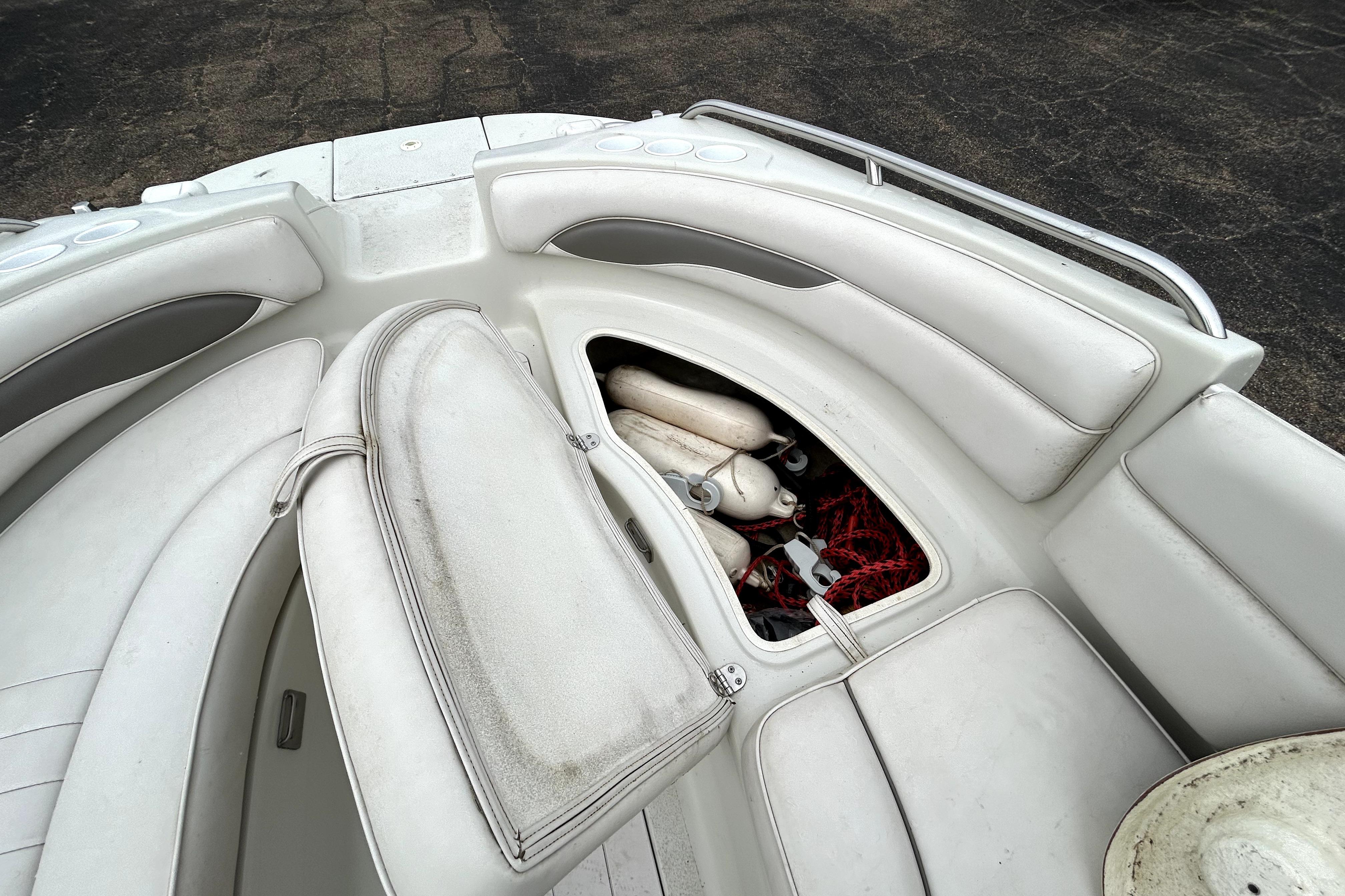 2001 Crownline 239 DB boat interior with open storage compartment, revealing ropes and fenders.