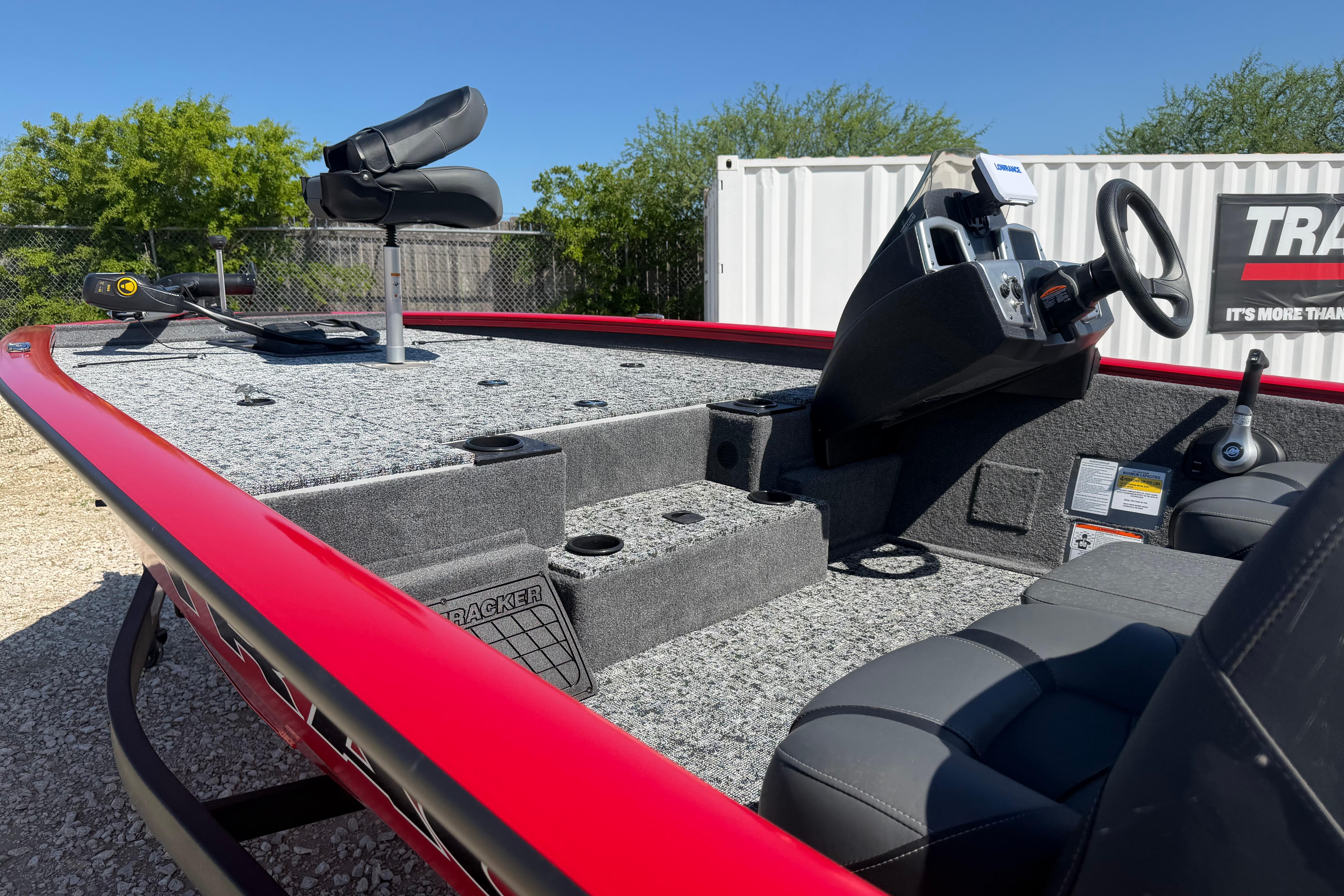 2026 Tracker Pro Team 195 boat interior with steering console and seating, parked outdoors.