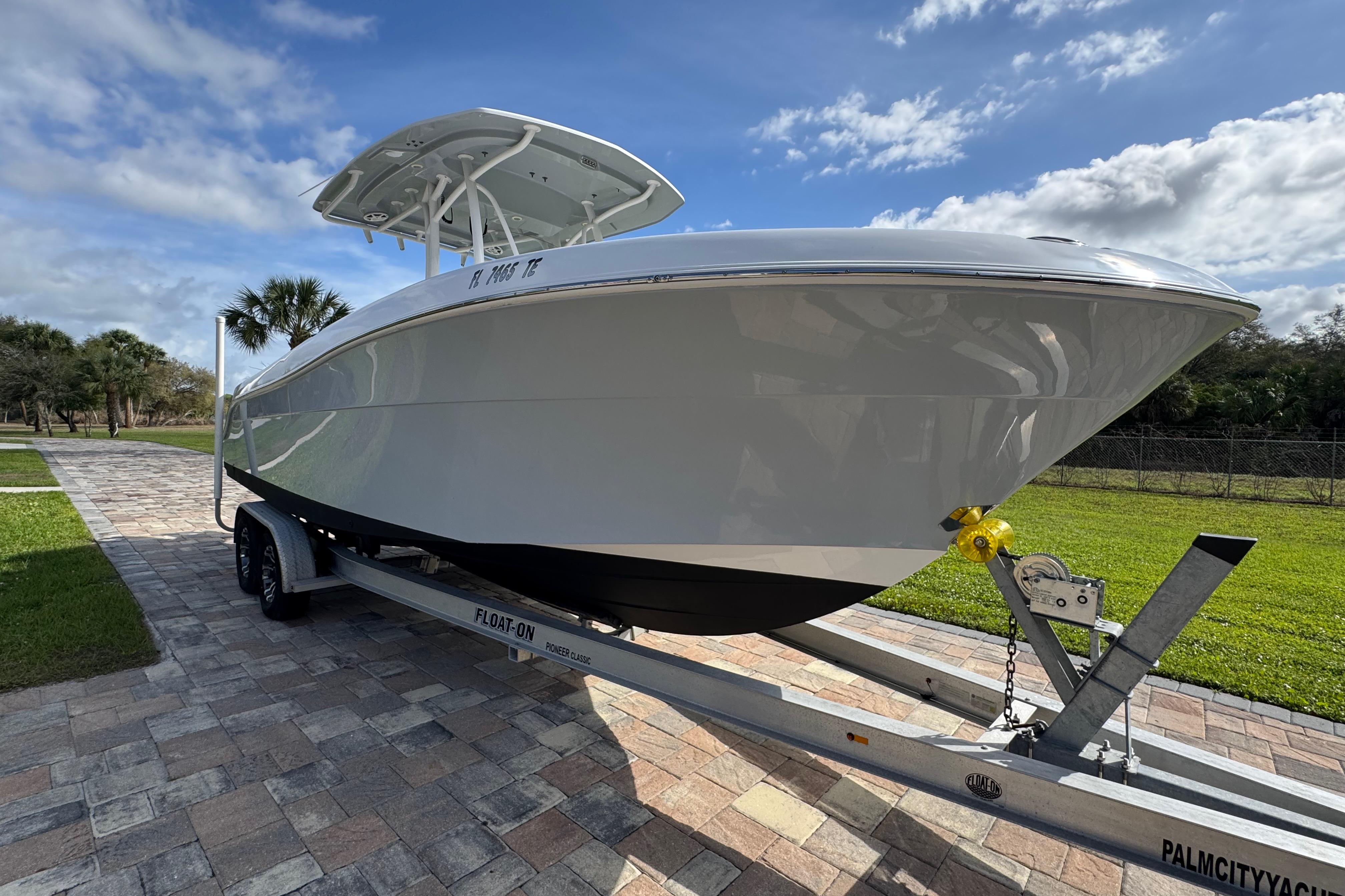 2022 Aquasport 2500 Center Console boat on trailer, parked on paved driveway.