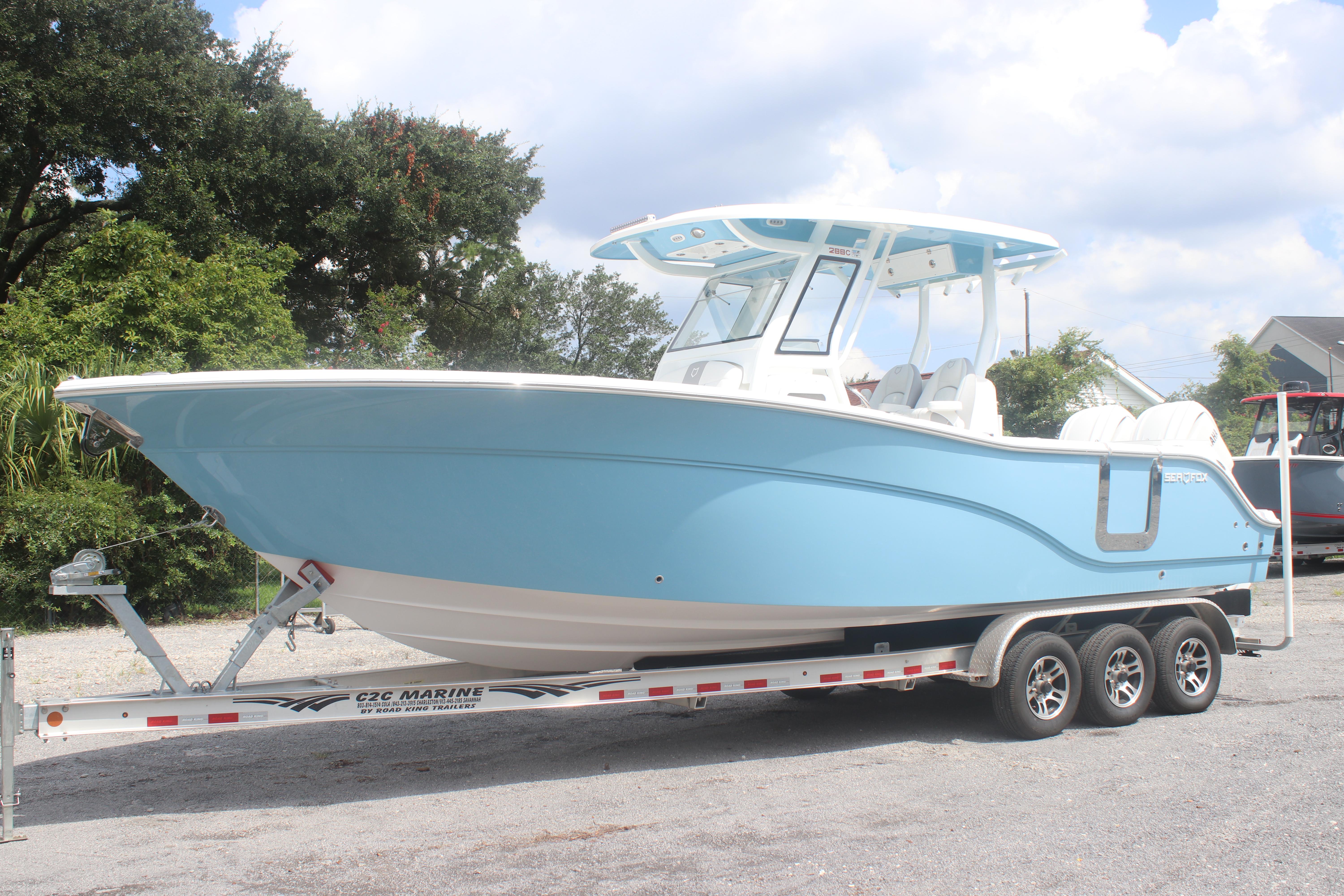 2026 Sea Fox 288 Commander boat on trailer, light blue hull, parked outdoors.