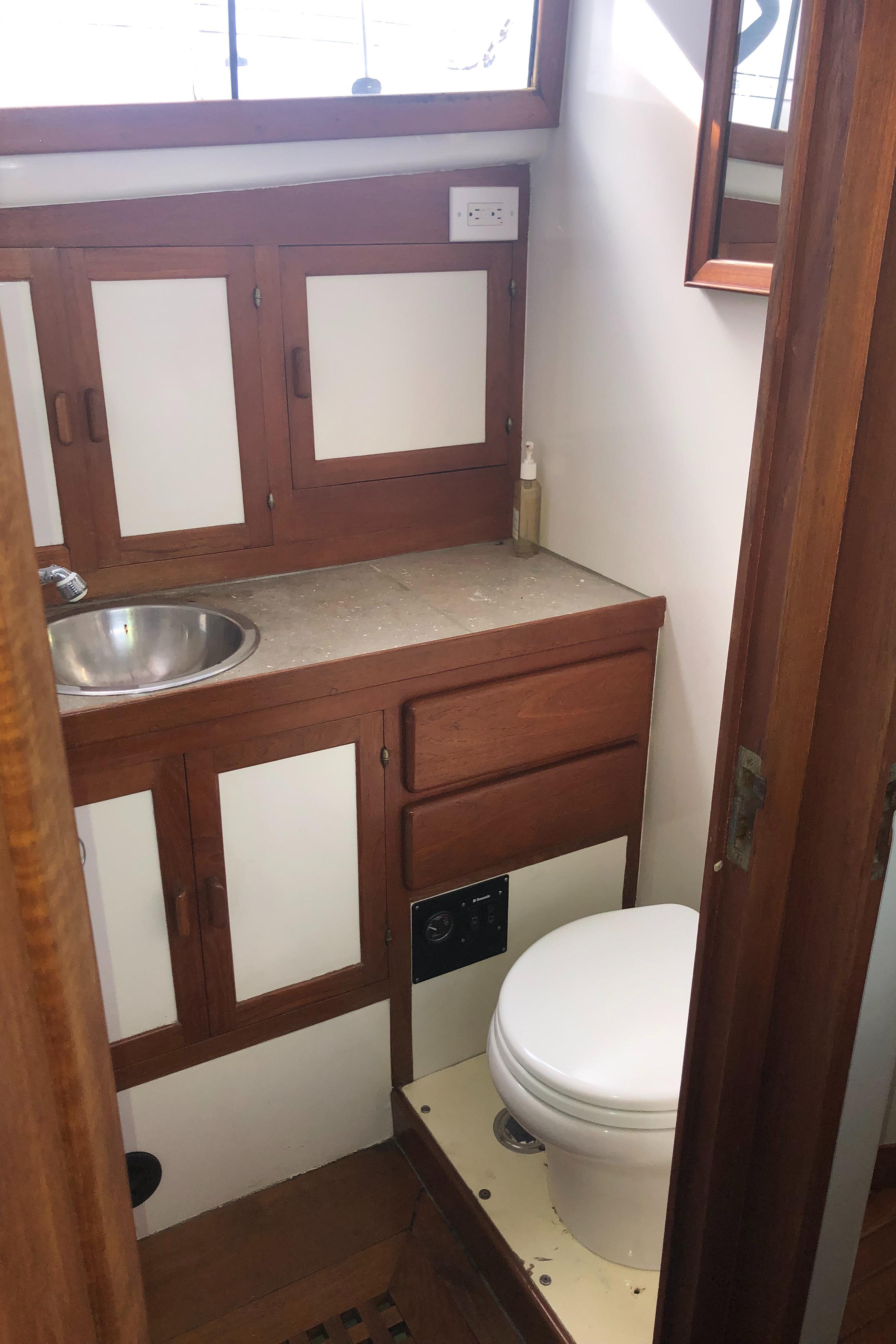 1981 Rough Water 37 Sedan boat bathroom with wooden cabinets and compact design.