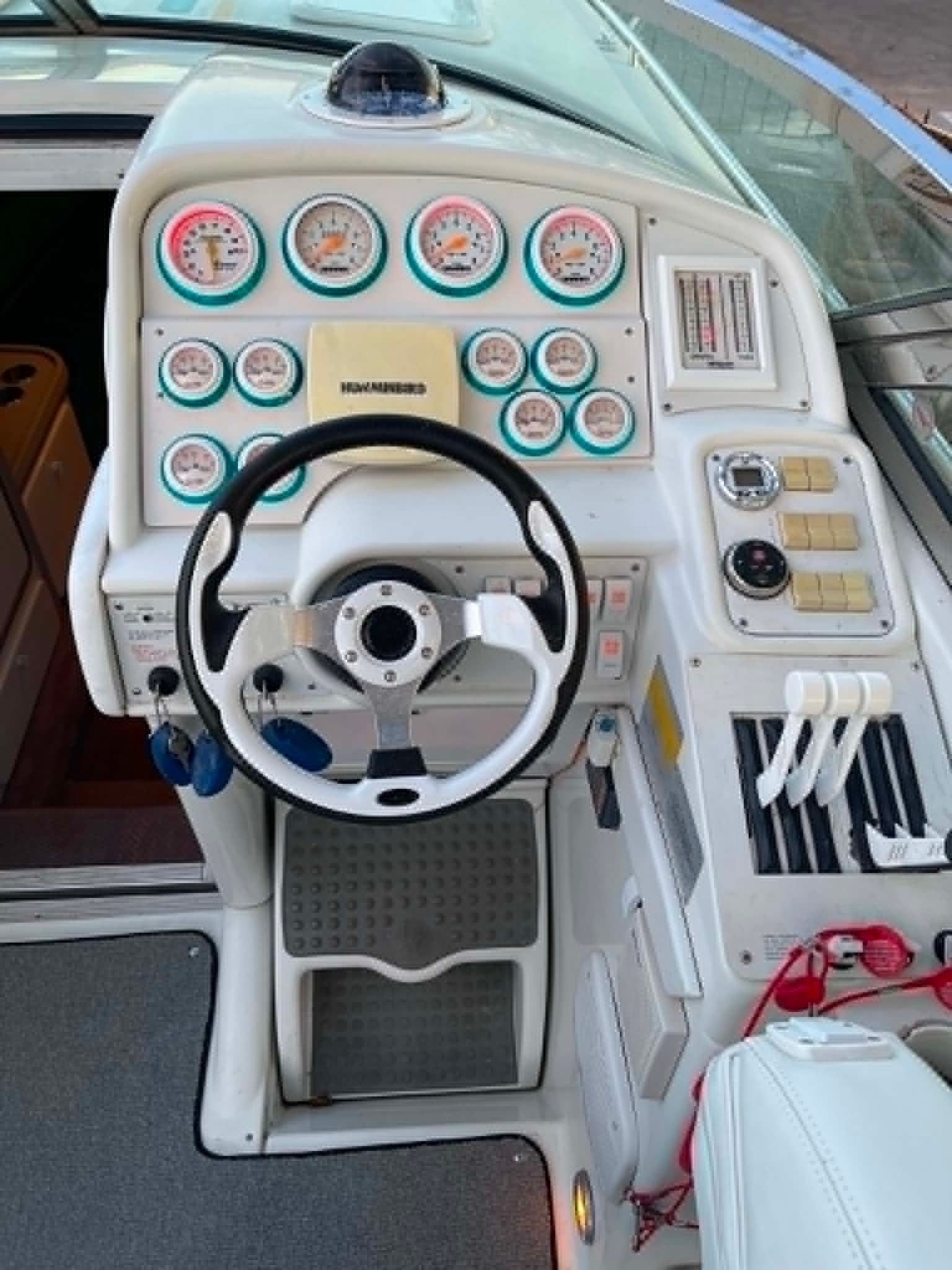 The cockpit of a 2000 Formula 419 Fast Tech with a white steering wheel and numerous gauges.