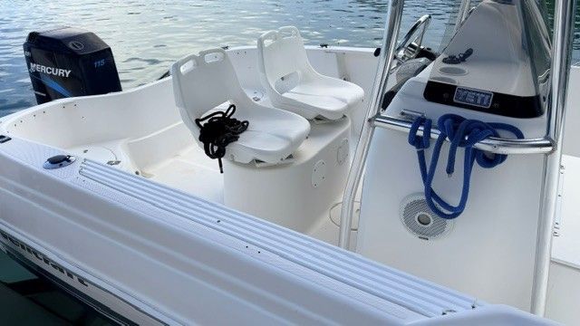 A 2004 Wellcraft 180 Fisherman boat with two white seats and a Mercury engine.