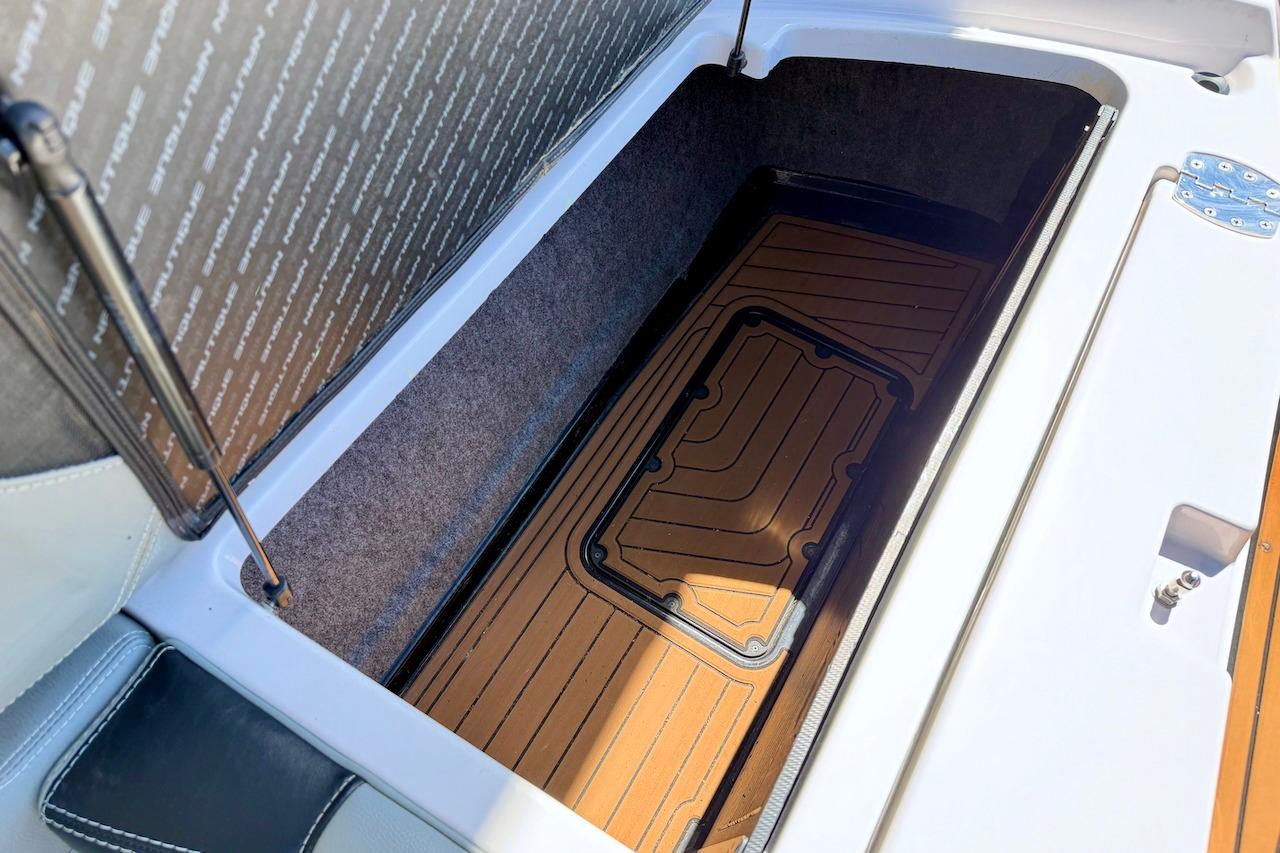 2014 Nautique Super Air Nautique G21 storage compartment with cushioned interior and hydraulic lift.