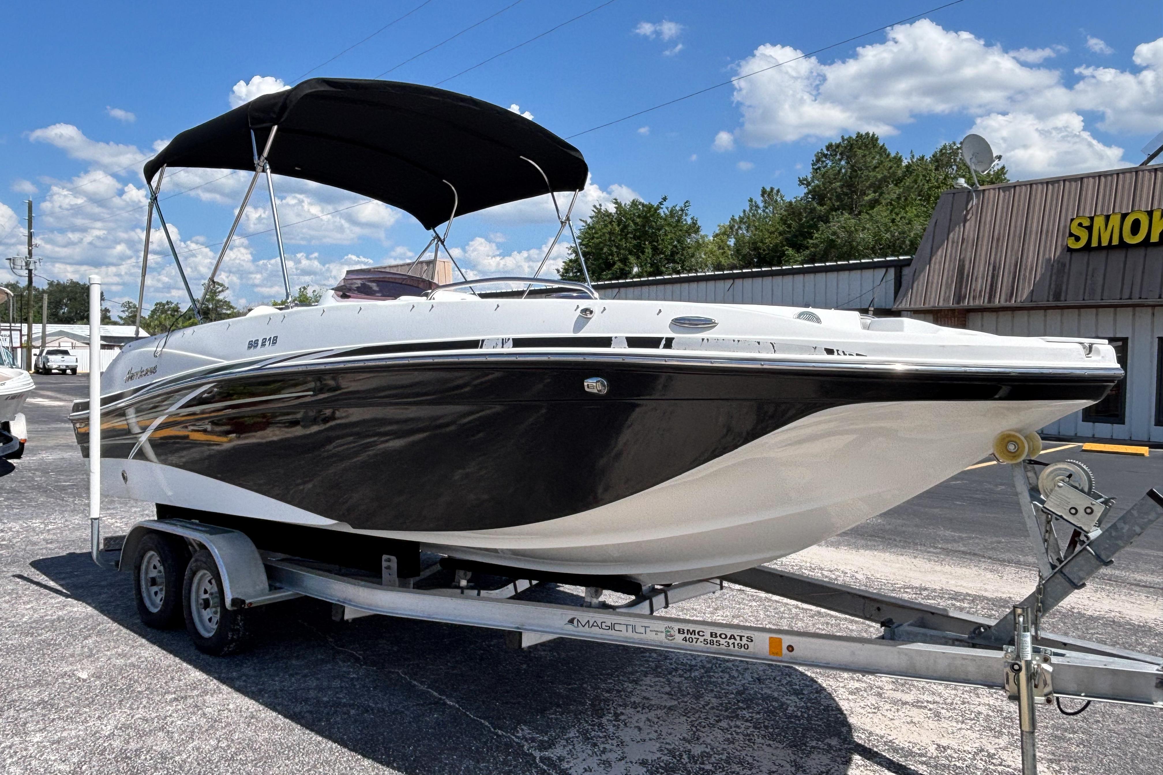 2019 Hurricane Sundeck Sport 218 OB boat on trailer, under sunny skies.