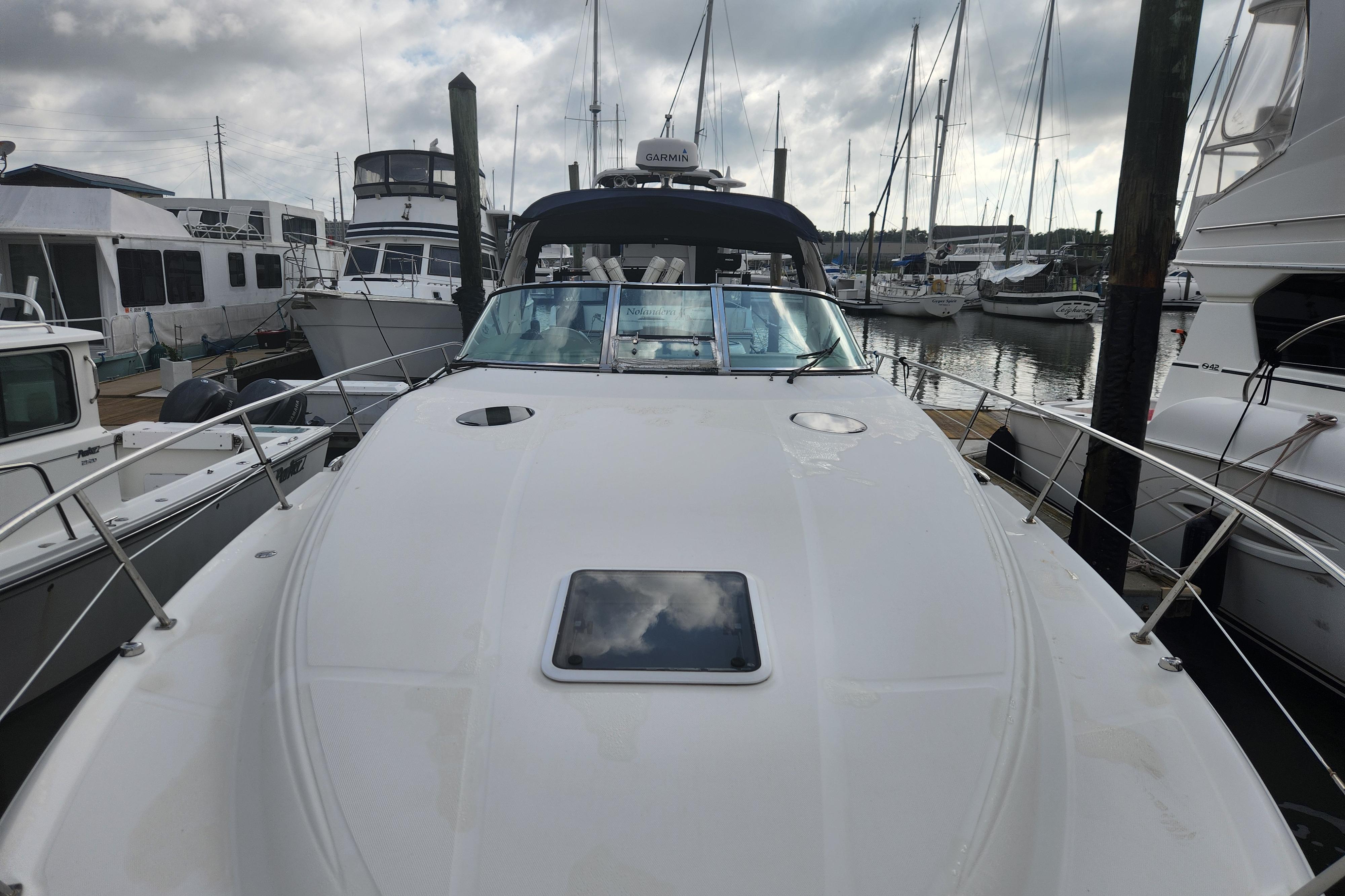 2003 Sea Ray 360 Sundancer yacht docked at a marina under cloudy skies.