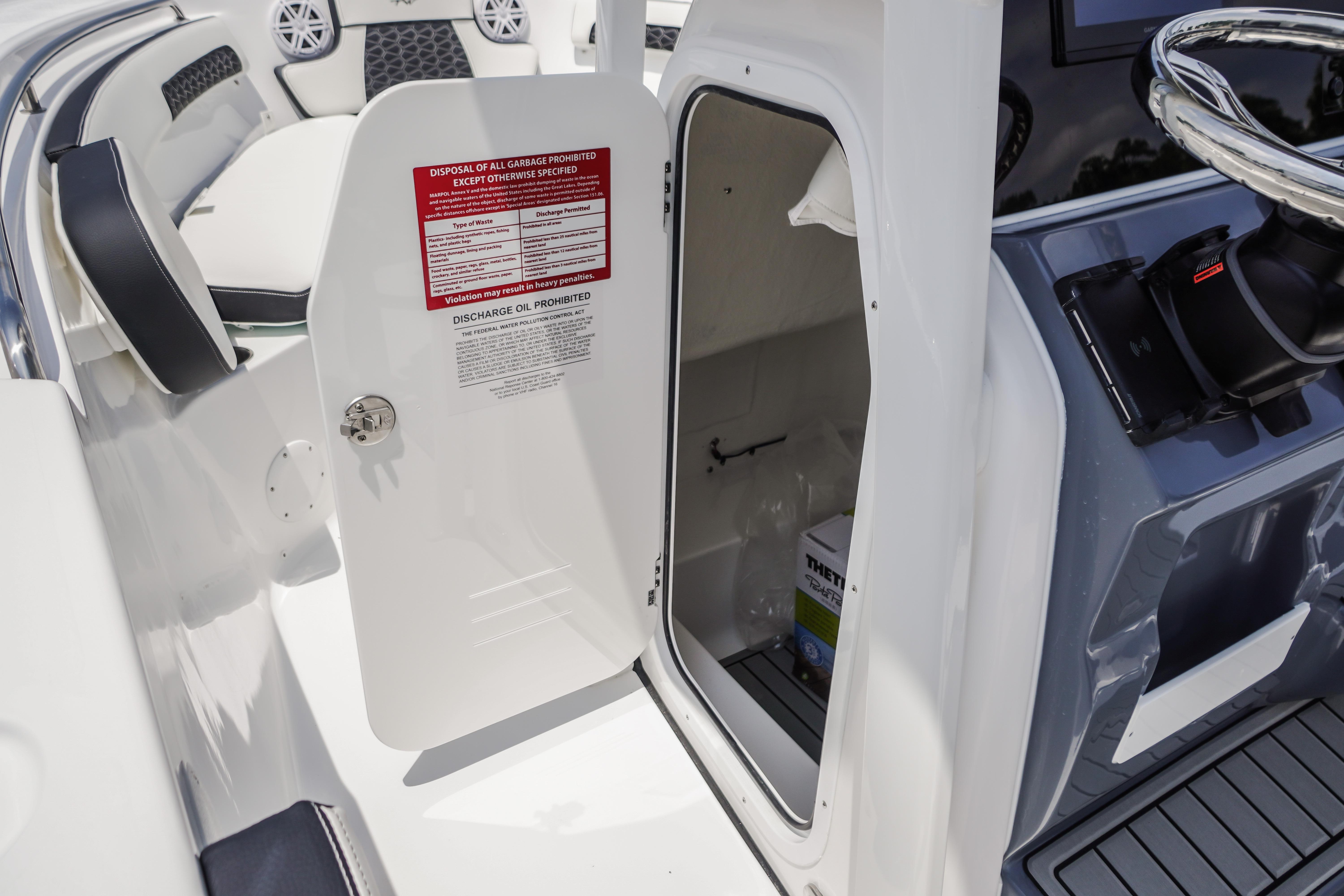 2027 Tidewater 220 CC Adventure boat interior with open storage compartment and seating area.