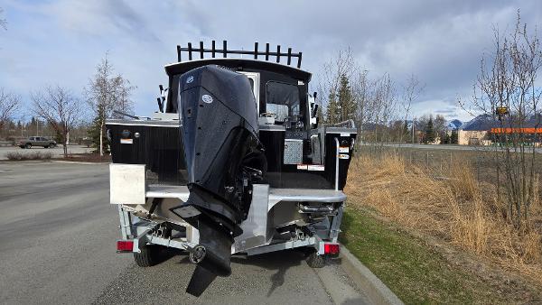 2024 Spartan 220 Maximus boat with outboard motor, parked on roadside.