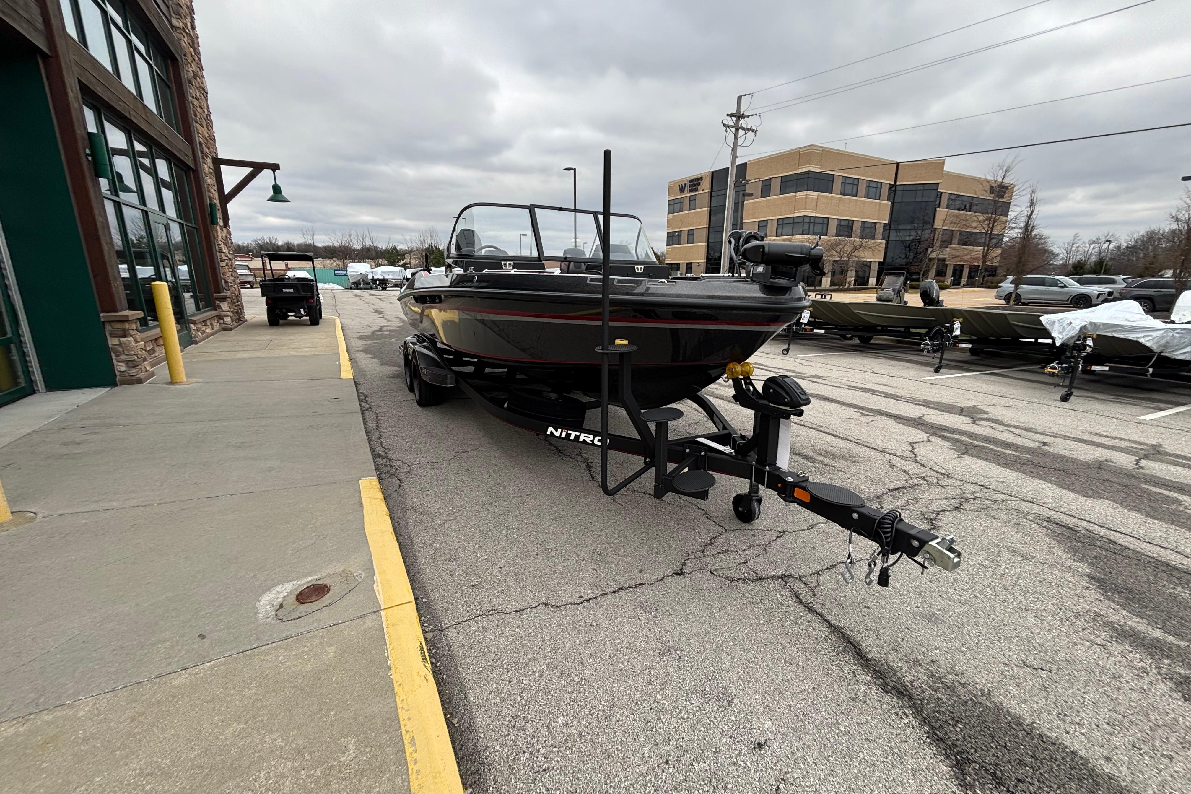 2024 Nitro ZV21 Pro boat on trailer in parking lot, overcast sky.