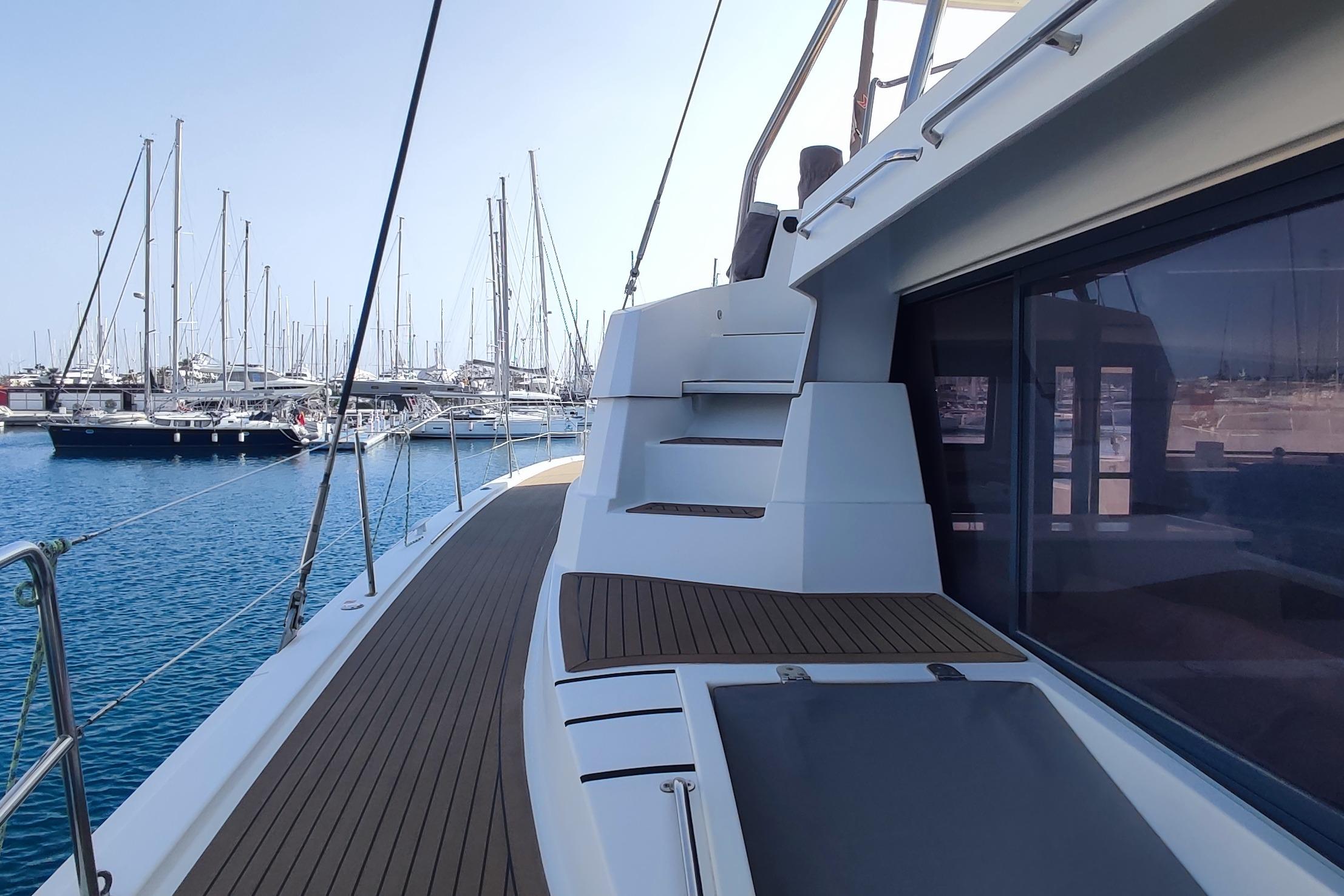Sleek 2021 Bali 5.4 yacht docked in marina, showcasing modern design and spacious deck.
