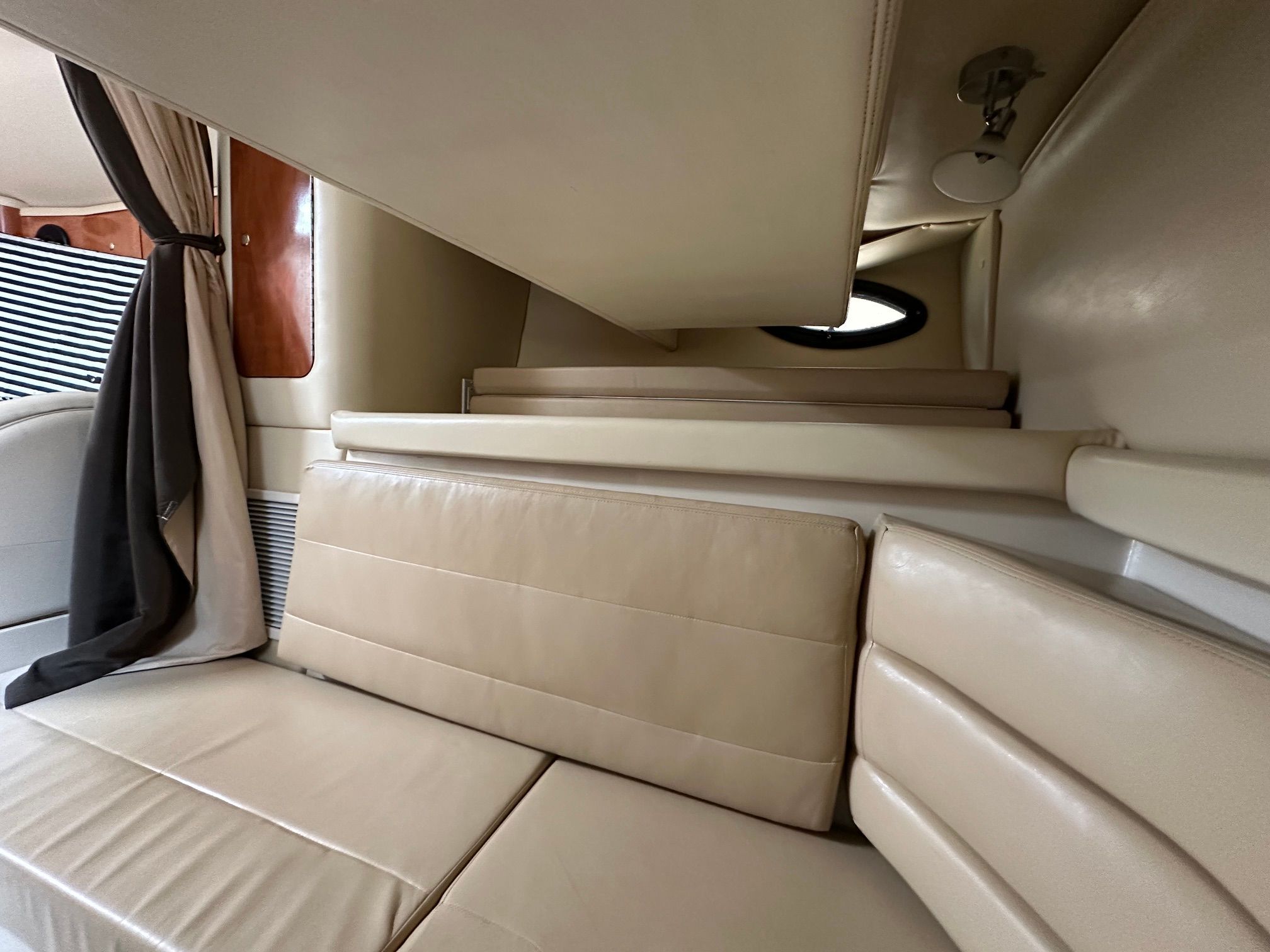 Interior of a Larson Cabrio 370 with beige leather seating and curtains.