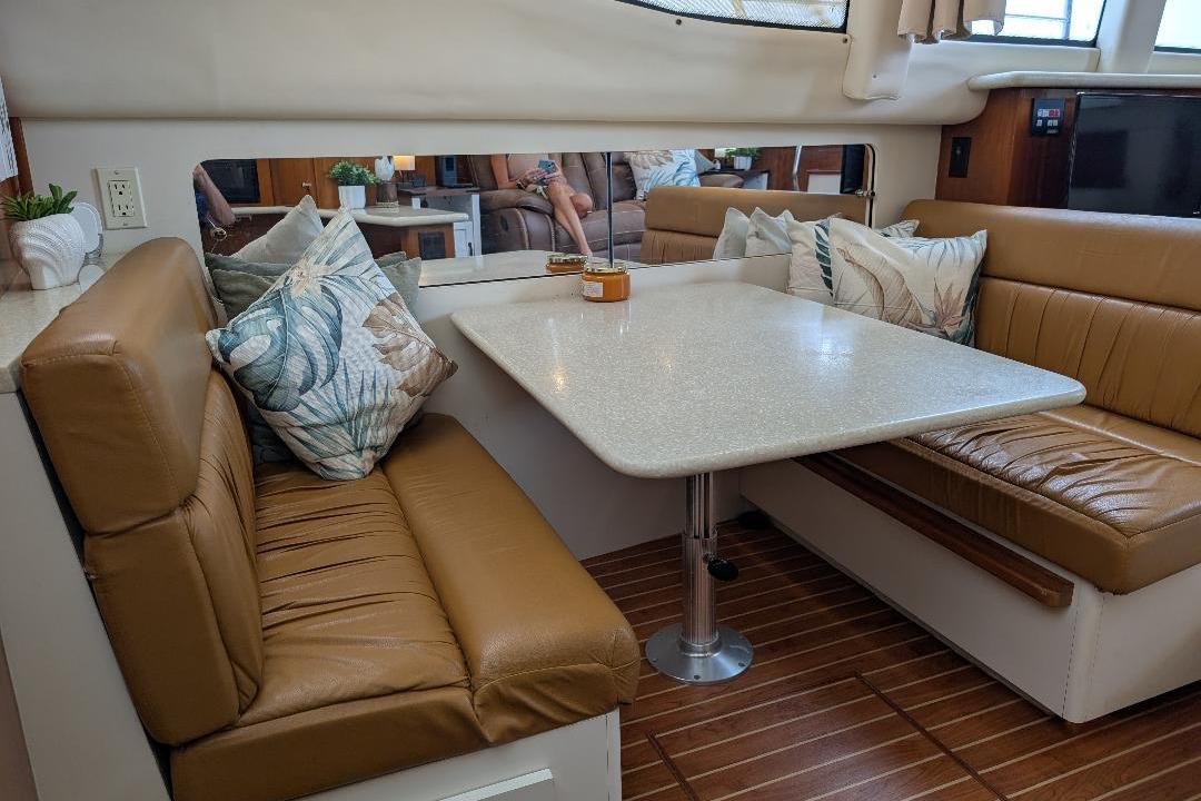 Interior of 2003 Carver 356 Motor Yacht with leather seating and dining table.
