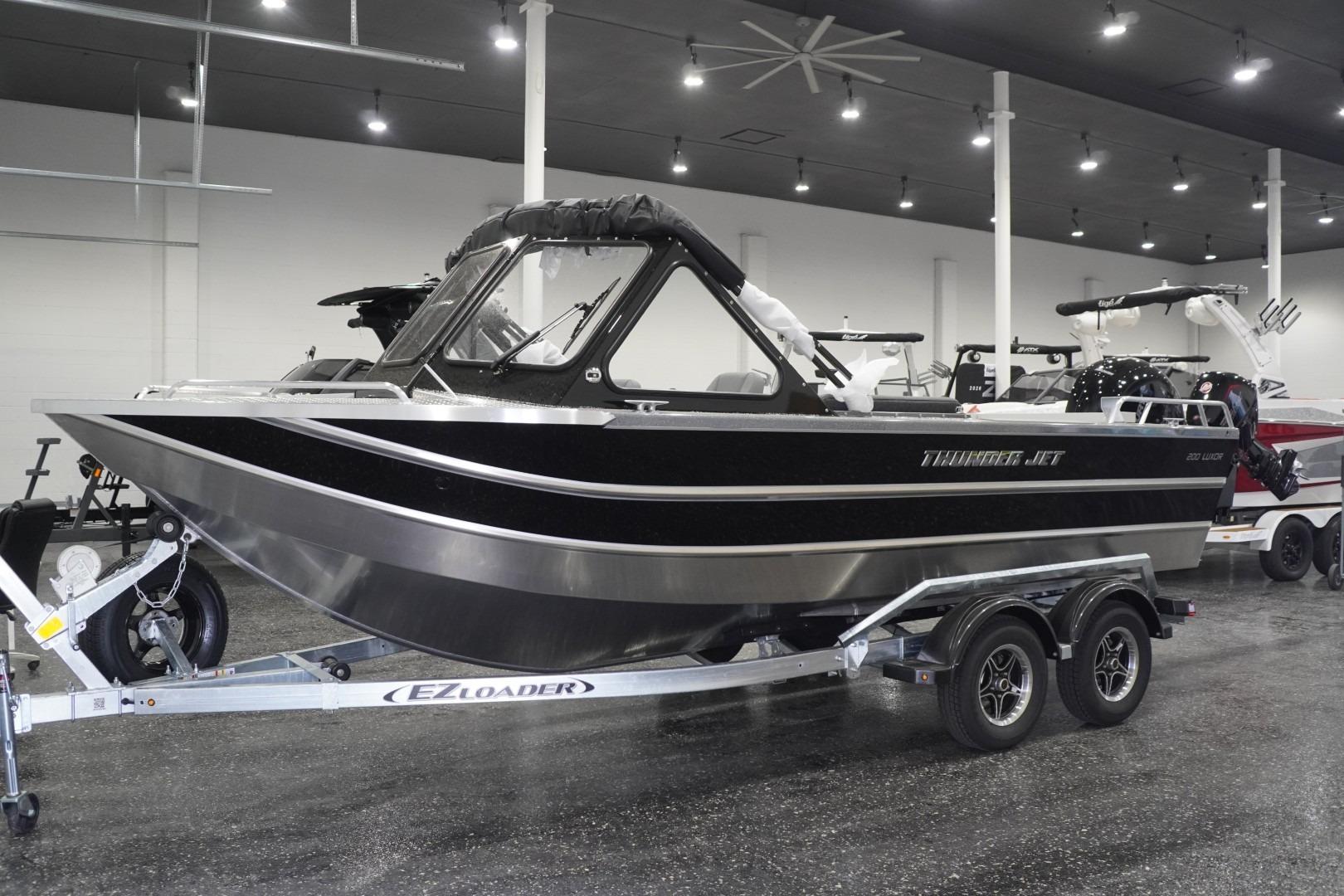 2026 Thunder Jet 200 Luxor boat on trailer in showroom, featuring sleek black design.