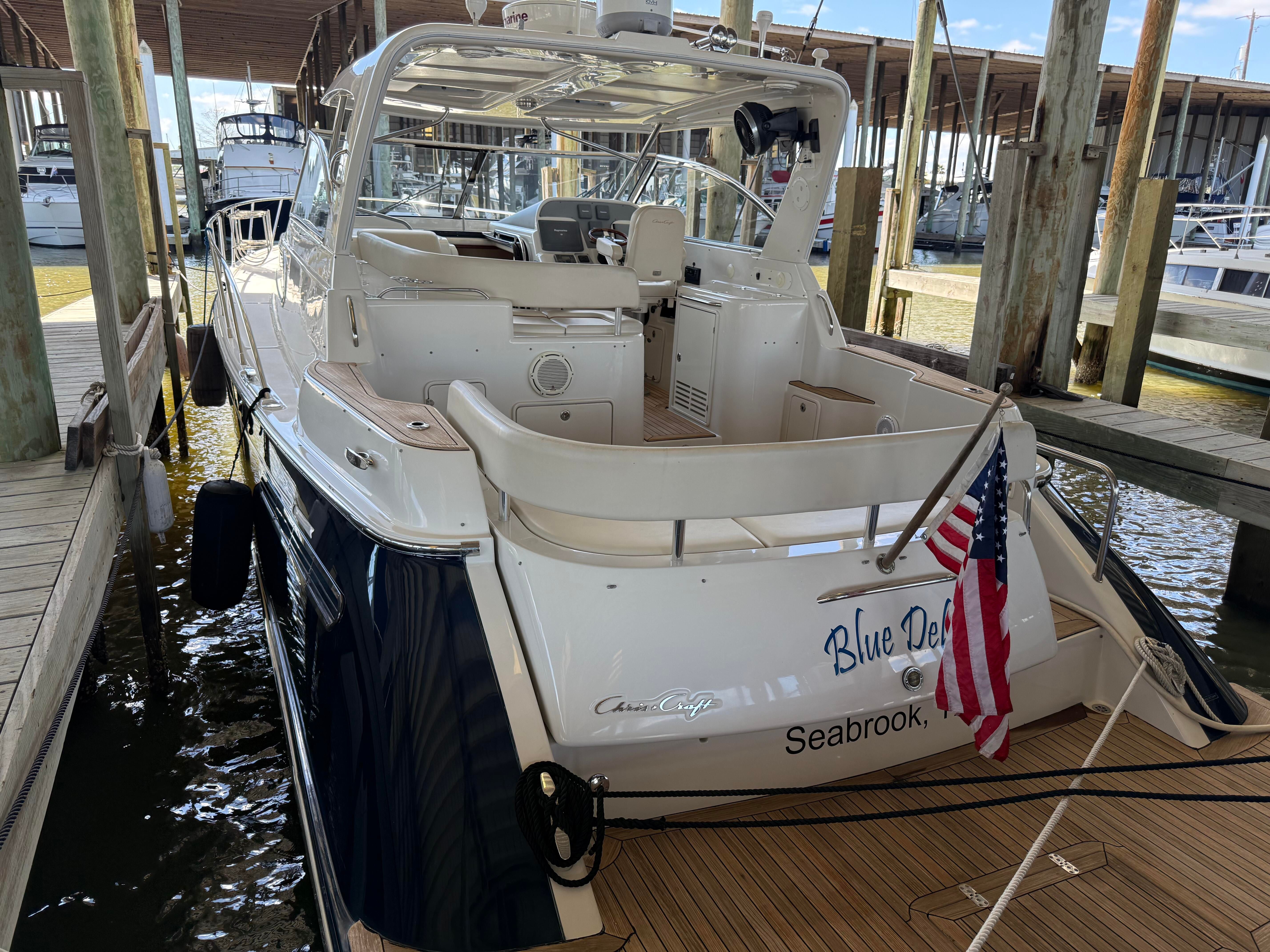 2007 Chris-Craft Roamer 40 docked in a marina, featuring an American flag at the stern.