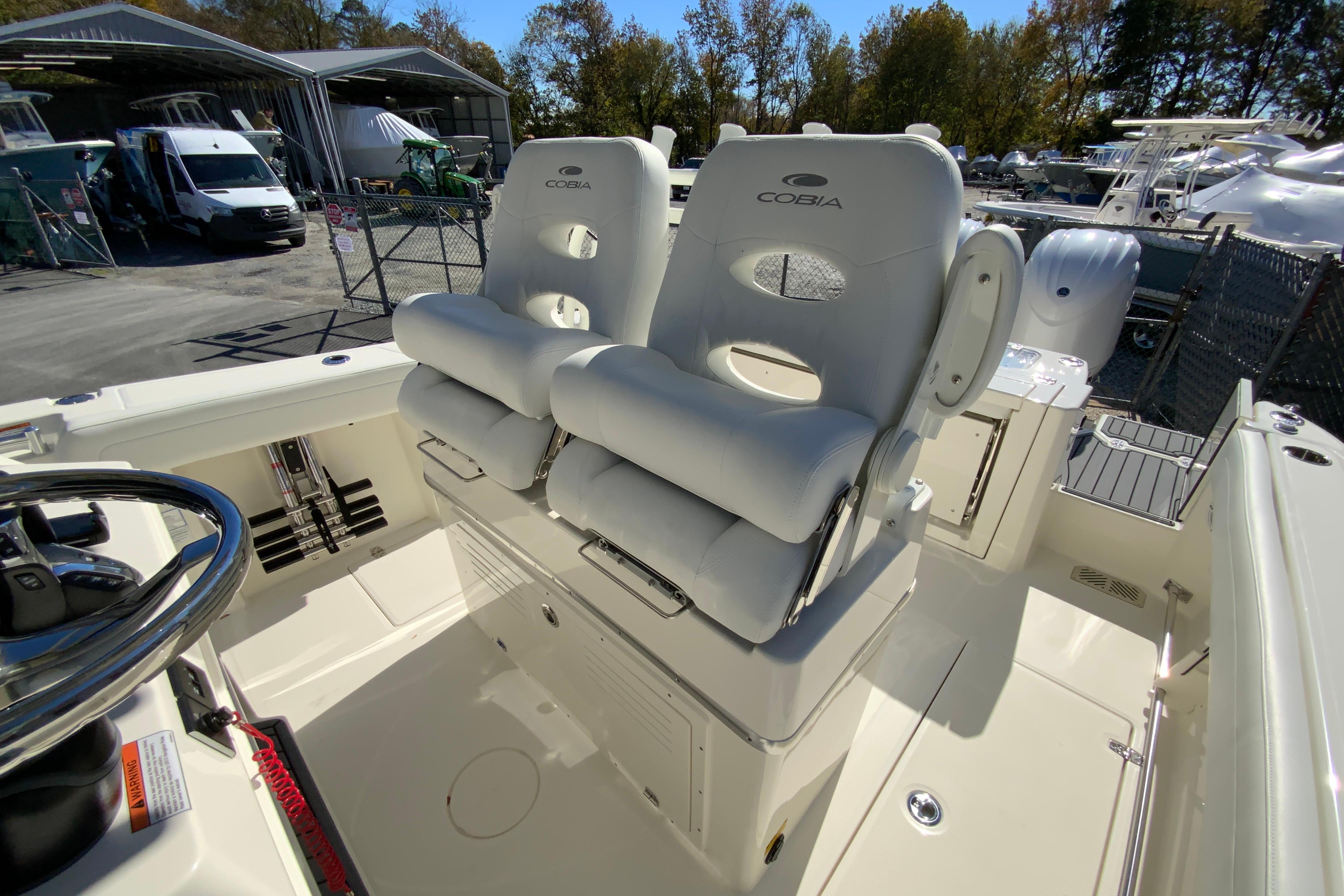 2026 Cobia 265 Center Console boat with dual cushioned seats and steering wheel.