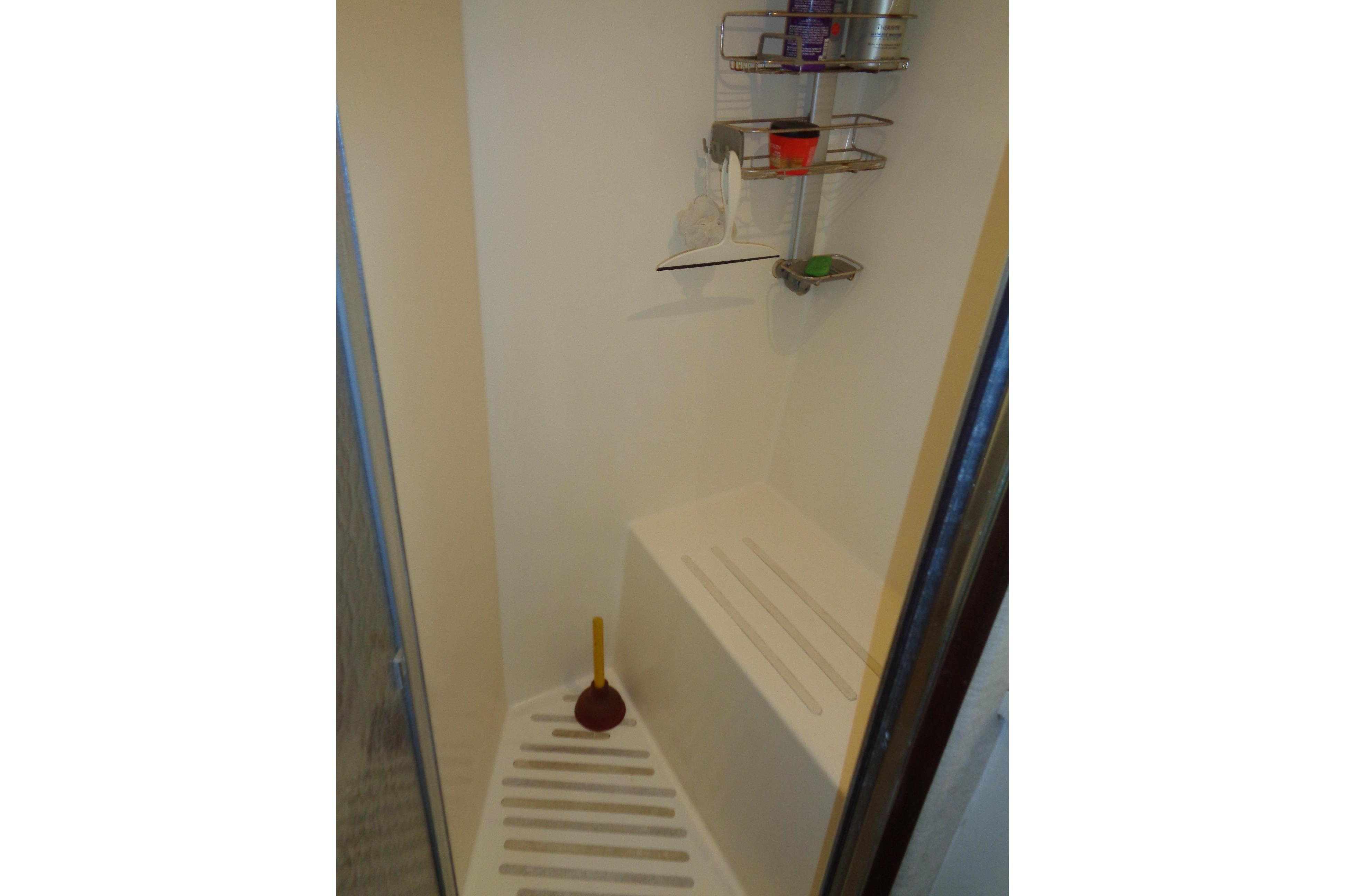 Shower area in 1981 Hatteras 48 Cockpit Motor Yacht with shelves and plunger.