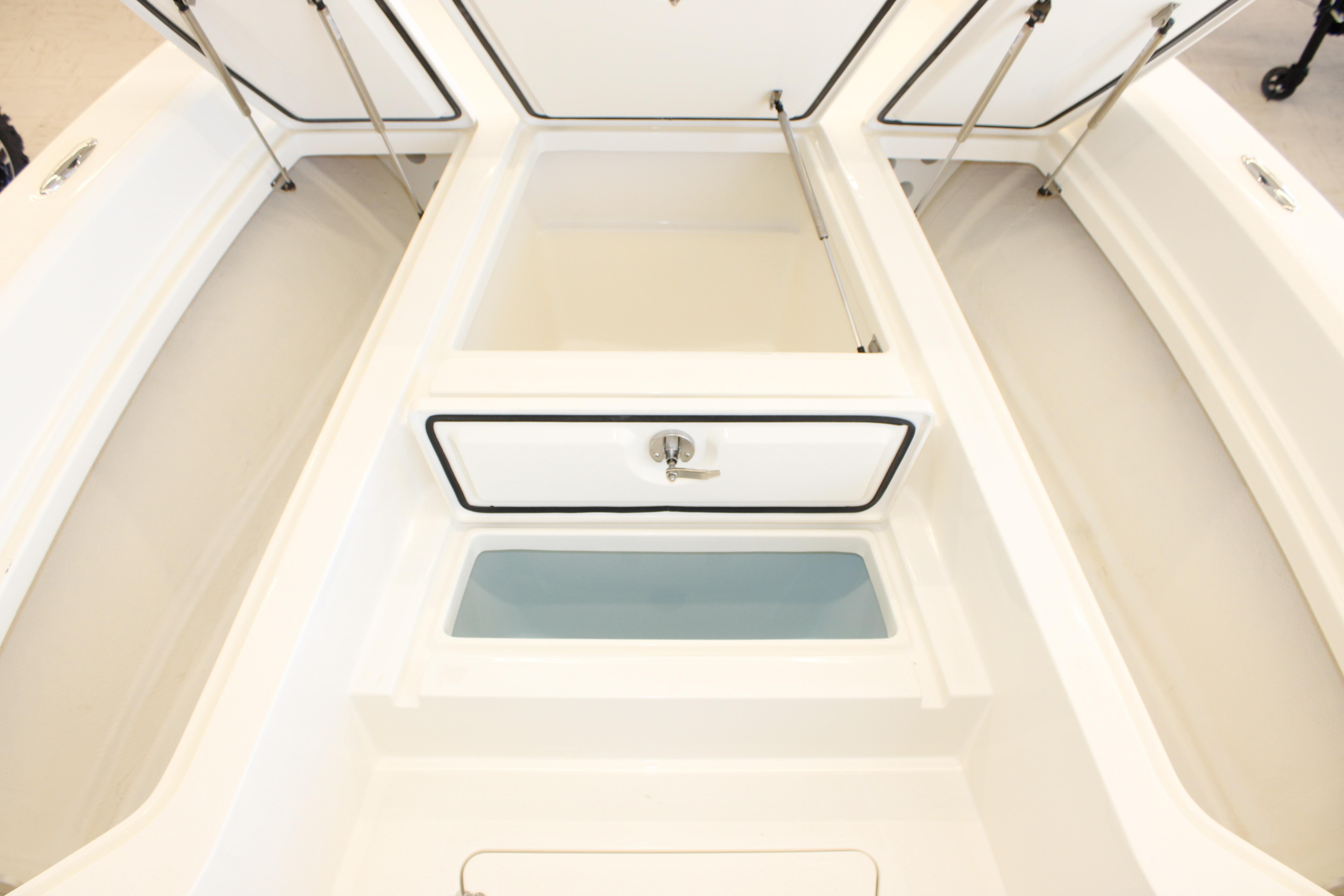 2026 Mako 24 APEX boat interior storage compartments with open hatches.