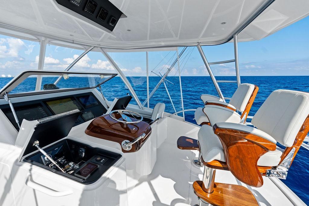 Helm of 2022 Viking 48 Convertible yacht with ocean view and luxury seating.